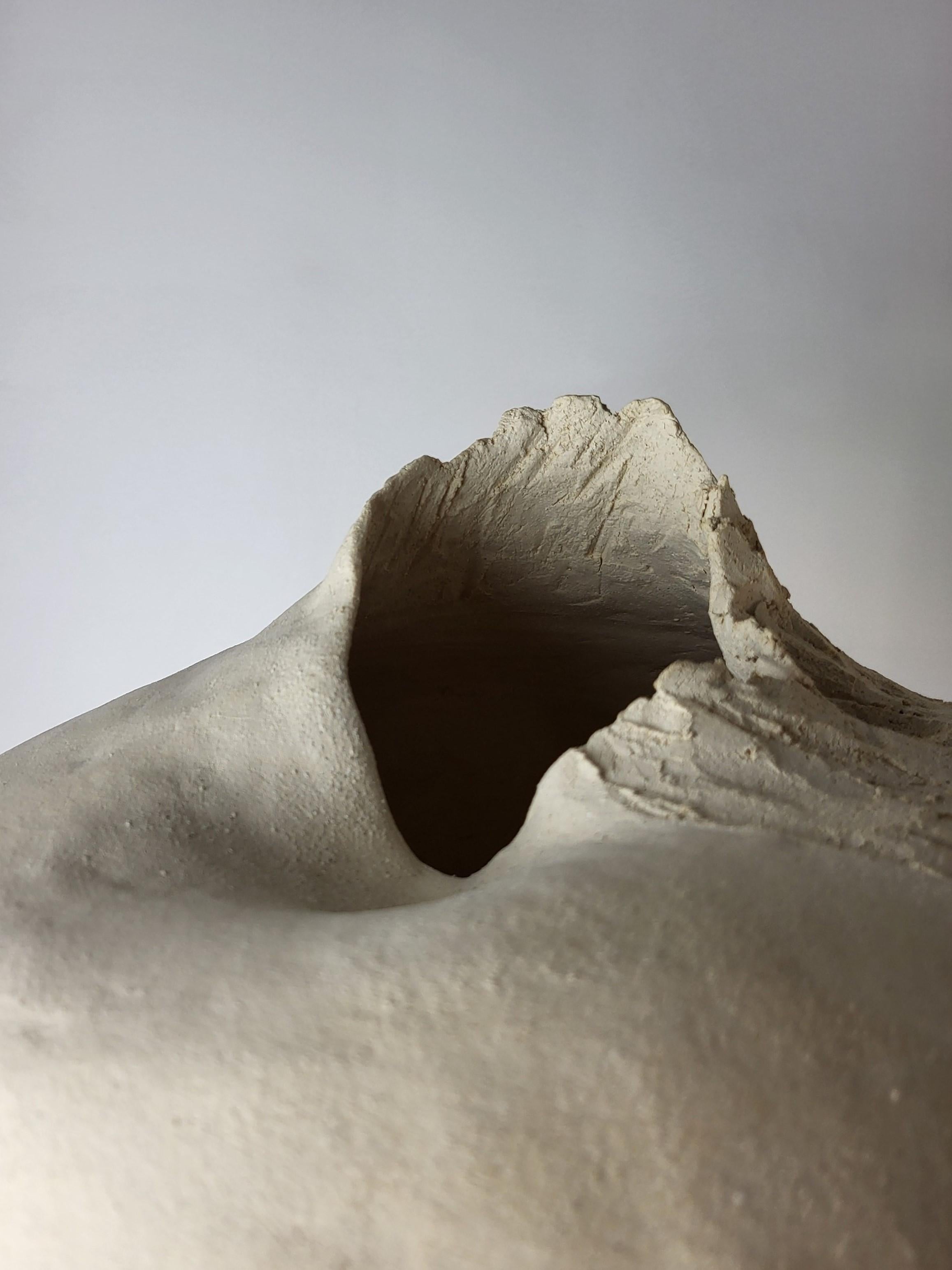 Erosion’s Memory I is a hand-built ceramic sculpture by French artist Audrey Vo Van, shaped from natural chamotte stoneware. Its form, both grounded and ascendant, evokes a geological fragment : a landscape eroded by time and weather, yet still