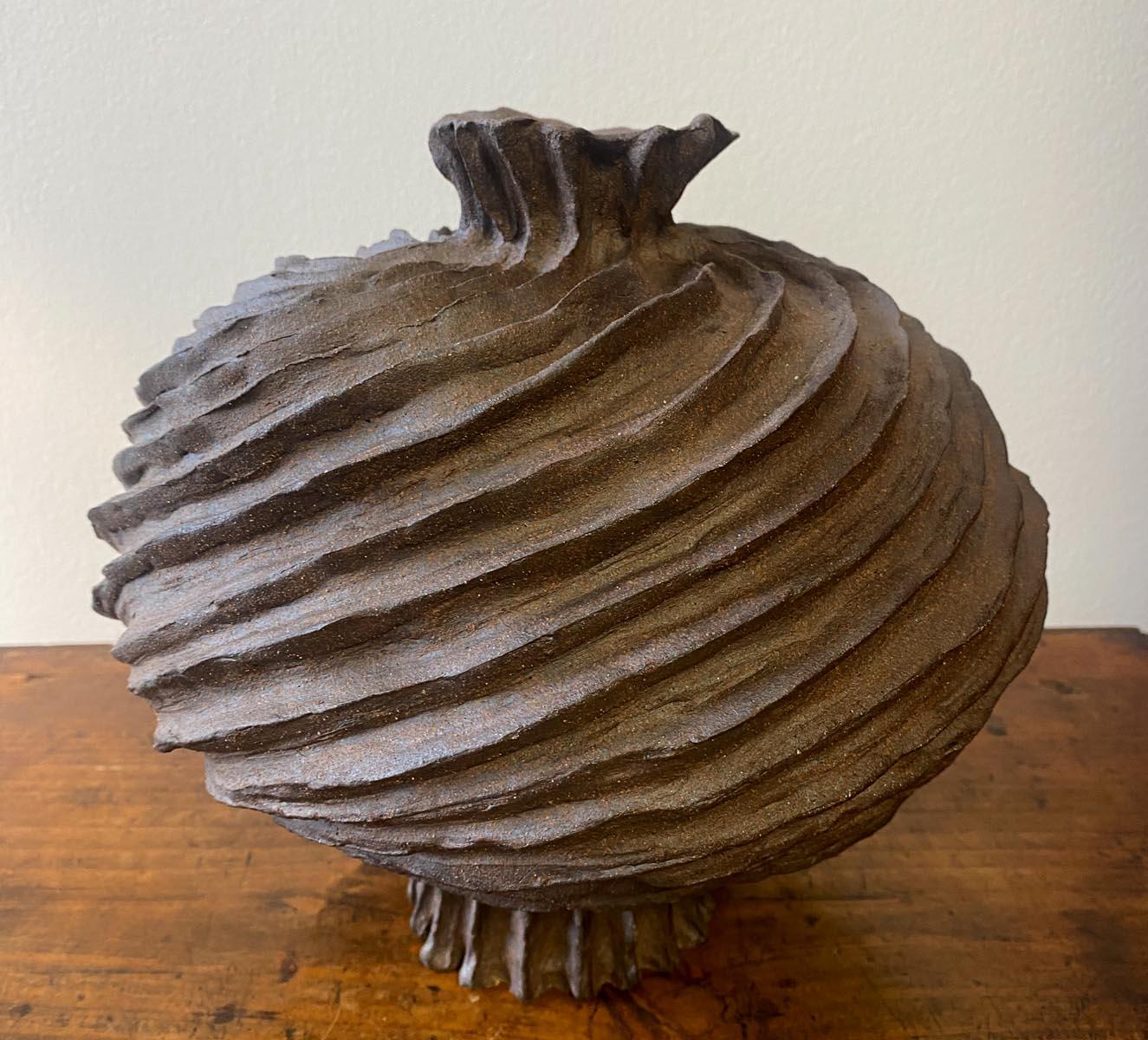Hand built clay vase with swirls, by ceramic artist Sally Terrell of Santa Barbara, California. Dark, high fired clay, unglazed.