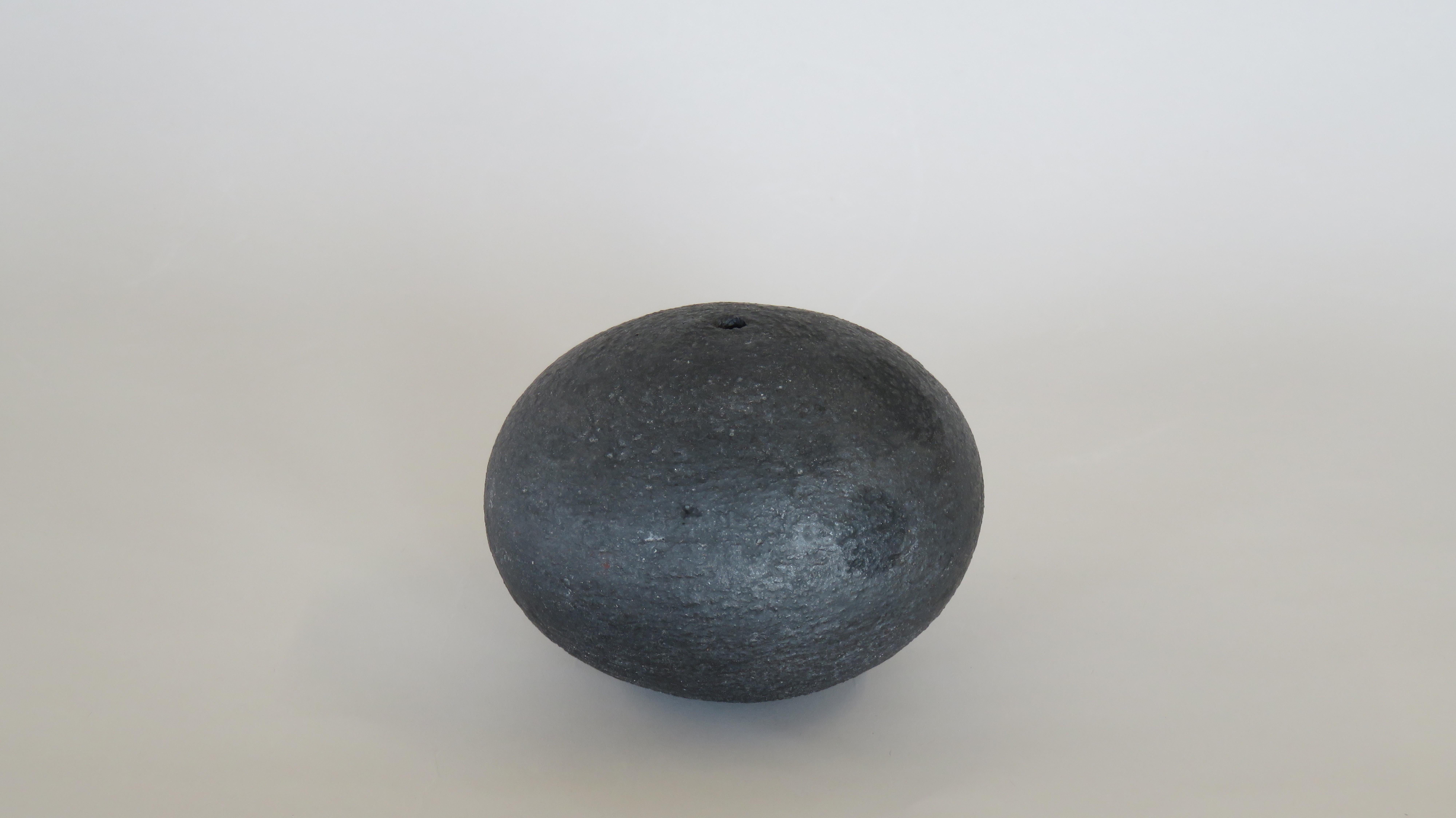 A hollow weighted sphere with an opening at top and bottom like an oversized bead.  This piece is for contemplation, meditation, to let your thoughts come and go. Or just as a paper-weight.  Or for a dried flower.  It does NOT hold water as there