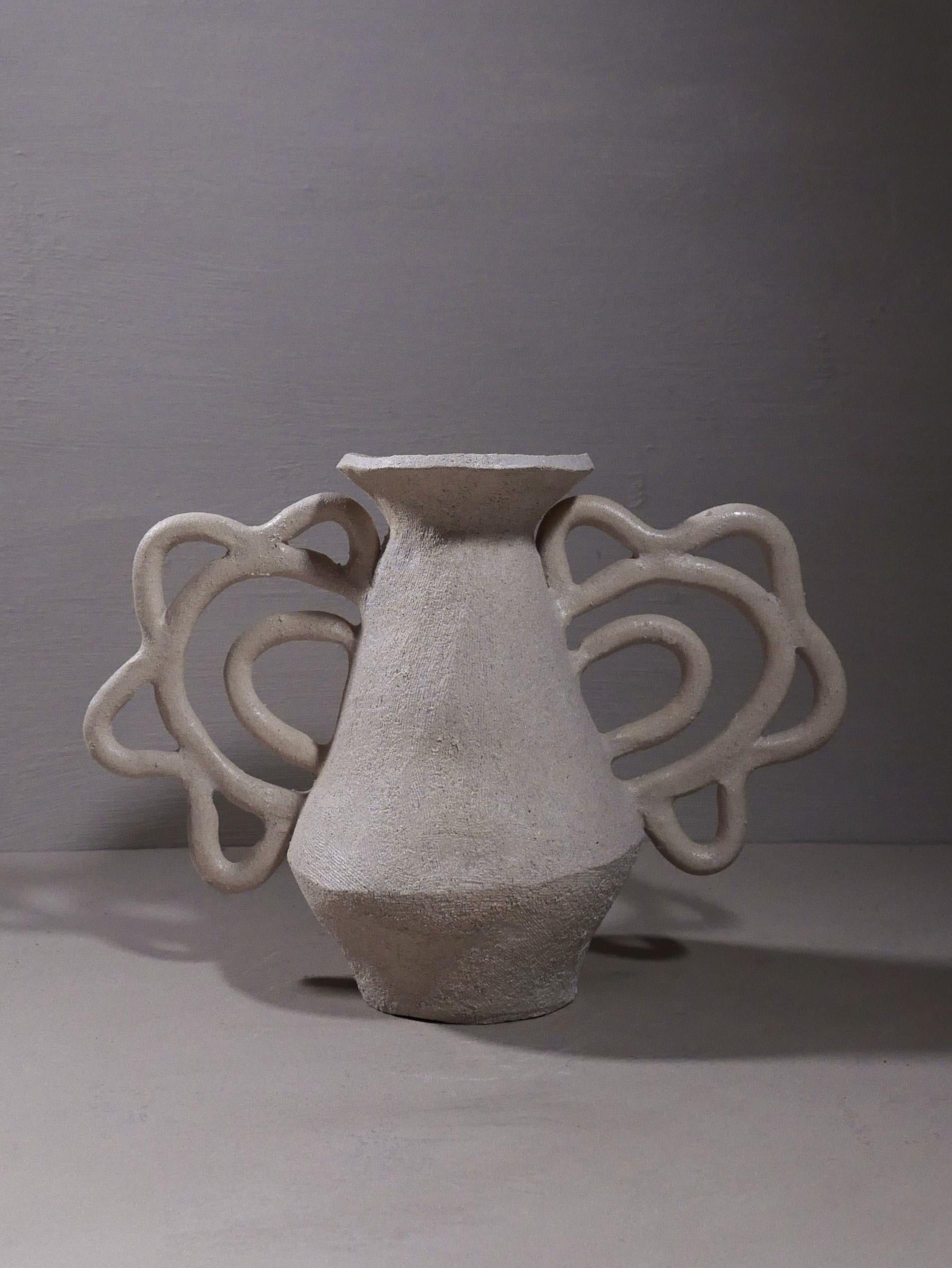 One-of-a-kind vase with two very intricate lace-like handles, hand-built by artist Sophie Agullo in Spain.

Supple, warm white matte finish on the exterior, with a glaze on the interior making it water-safe.
