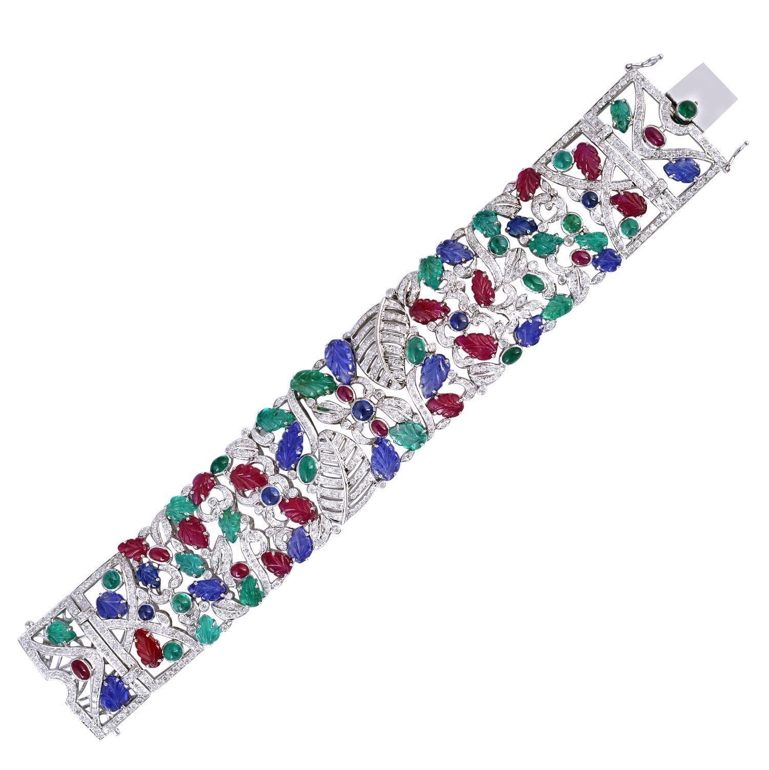 A stunning statement cuff handmade in 14K gold and hand carved leaf motifs set throughout. It is set in 13.07 carats emerald, 12.25 carats ruby, sapphire & 5.9 carats of sparkling diamonds. Clasp Closure

FOLLOW MEGHNA JEWELS storefront to view the