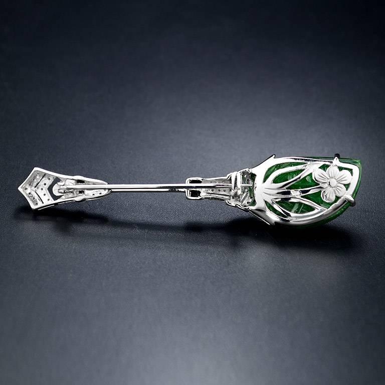 Carved Zambian Emerald 16.66 Carat set on 18K White Gold Pin/Brooch.  High-lighted by French Cut Onyx with 50 pcs. of Single-Cut Dimond total weight 0.27 Carat.