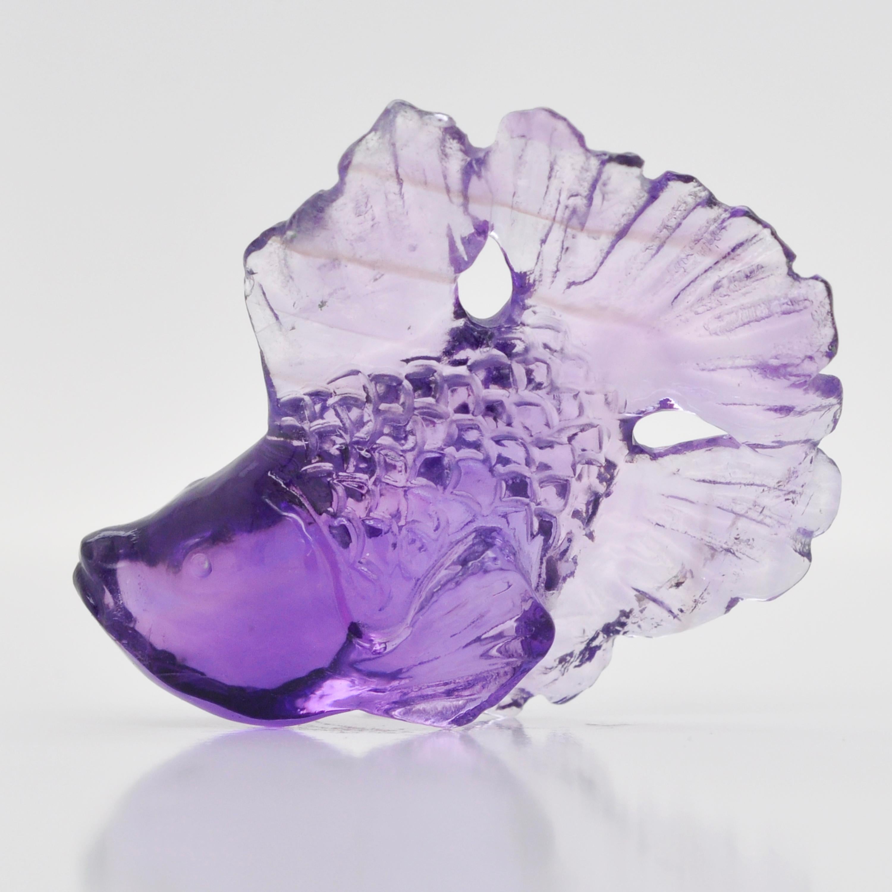 Our hand-carved 18.19 carats Natural African Amethyst Fish Loose Gemstone is a stunning work of art crafted by our expert lapidary artist in Jaipur. With exceptional skill and attention to detail, the lapidary artist has transformed a raw African
