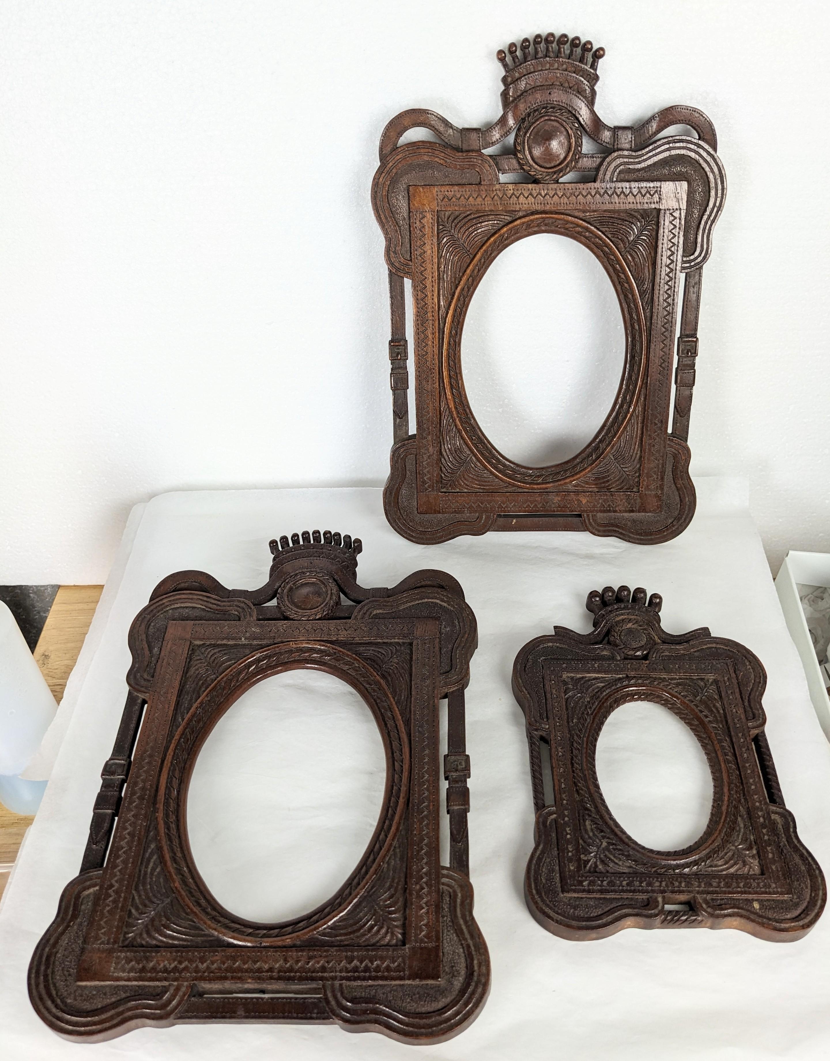 Charming set of 3 Hand Carved 19th Century European Frames. Beautifully hand carved wood (walnut?) with motifs with buckle straps, rope work and crown tops. Possibly Black Forest work, Germany-Austrian circa 1880's. (2) Large 11