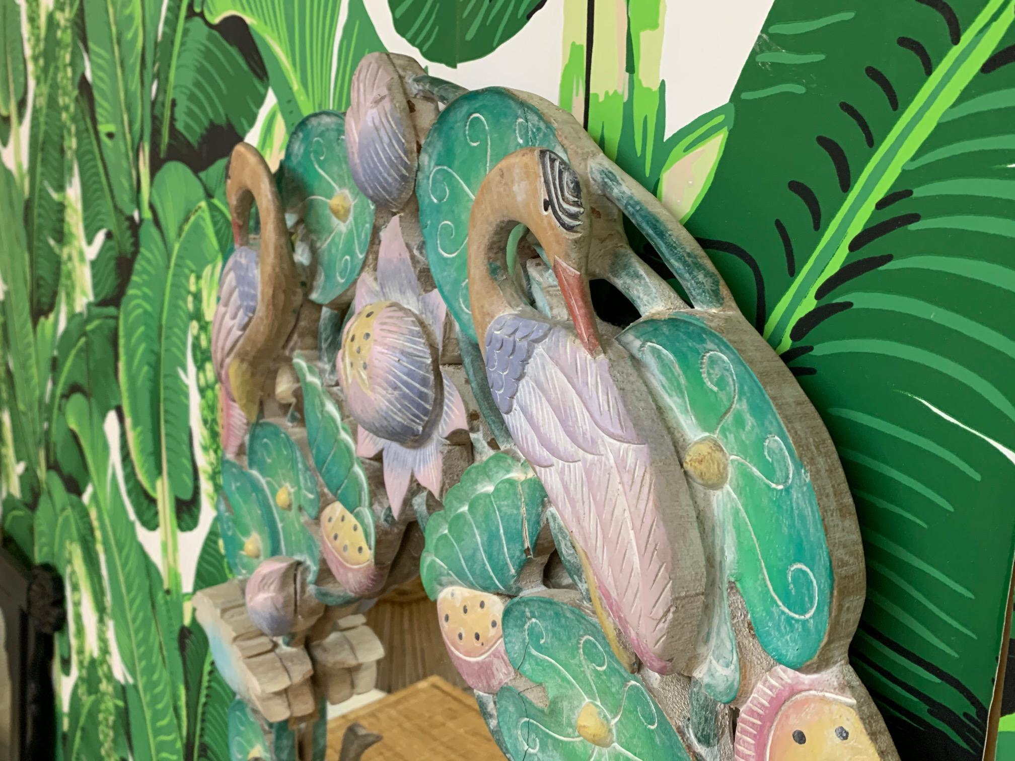 Tropical style mirror features a 3D carved wood frame with birds, lily pads, and flowers. Stands 37