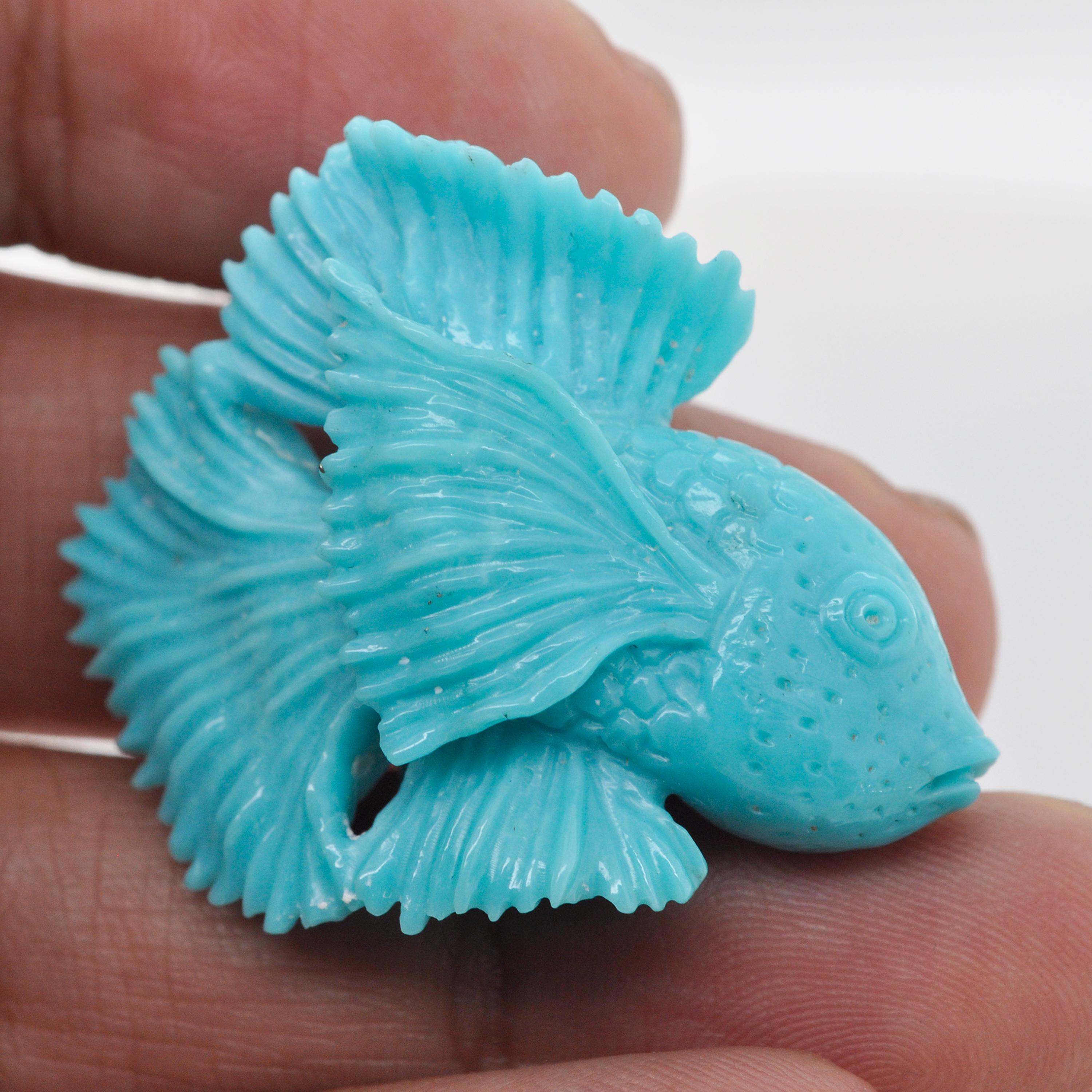 Our one-of-a-kind hand-carved Siamese fish on natural Arizona Turquoise is an extraordinary work of art created by our expert lapidary artist in Jaipur. With unparalleled skill and meticulous attention to detail, the lapidary artist has transformed