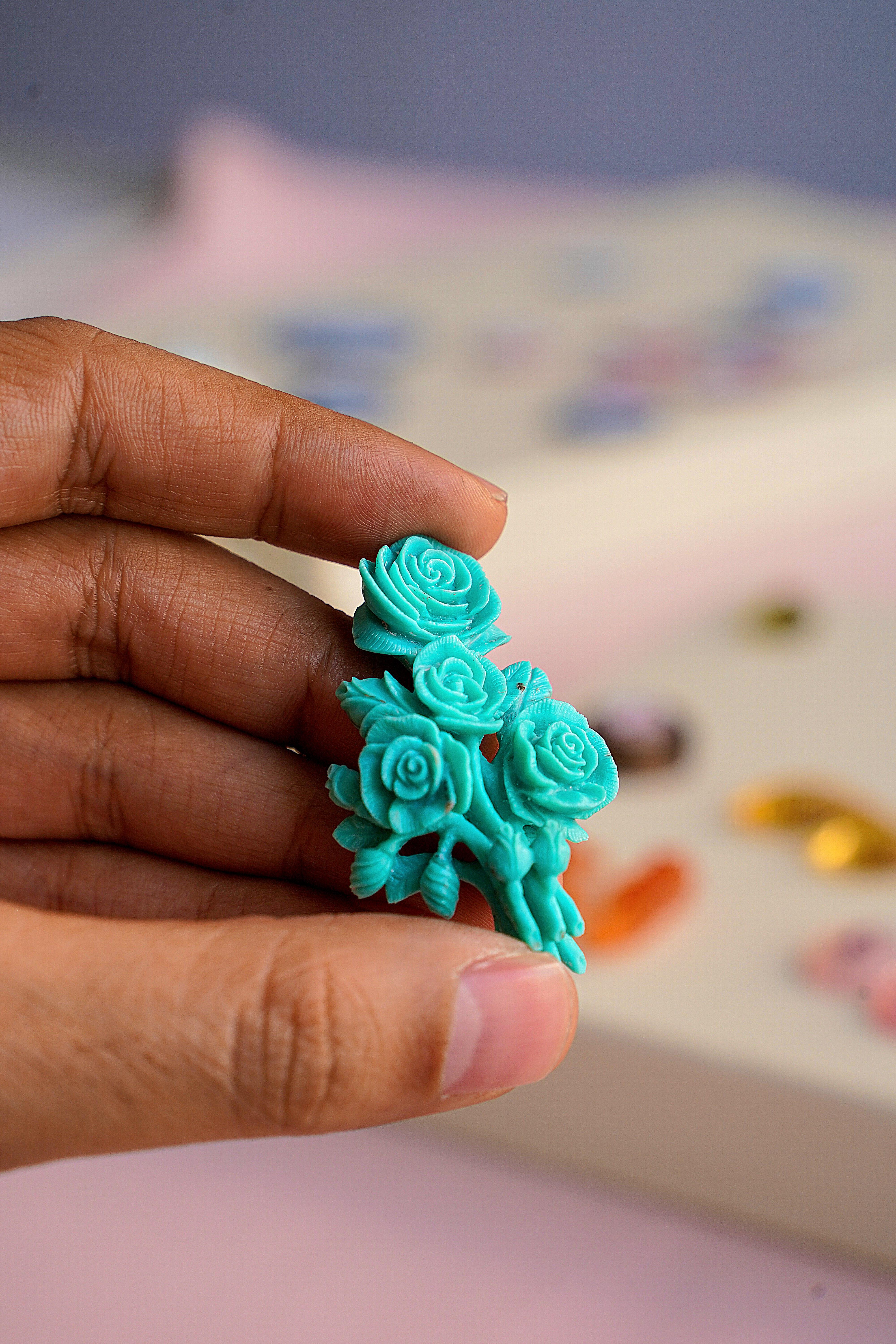 Our one-of-a-kind hand-carved bouquet of four roses on natural Arizona Turquoise is a remarkable piece of art created by our expert lapidary artist in Jaipur. With meticulous craftsmanship, the lapidary artist has transformed a raw stone into a