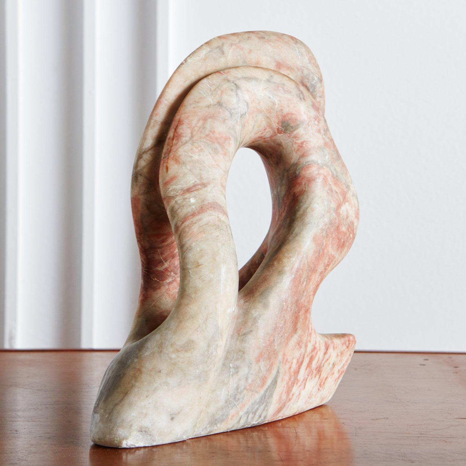 An abstract sculpture hand carved from a beautiful coral marble with striking gray and cream veining. We love the organic curves and freeform shape on this vintage beauty. Unsigned.