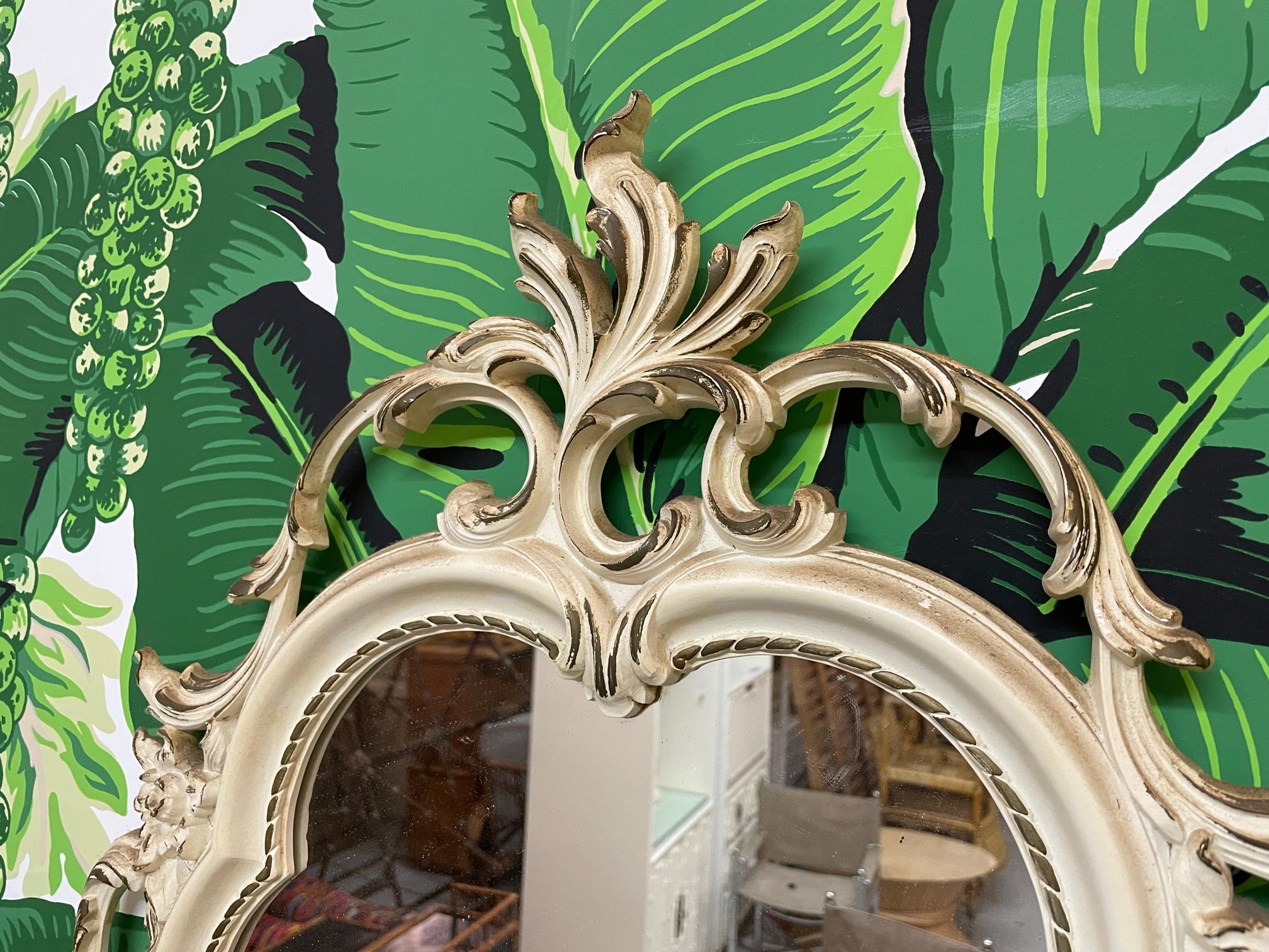 Ornate hand carved mirror by Syroco features intricate acanthus leaf scrollwork surrounding frame. Very good vintage condition with minor imperfections consistent with age.