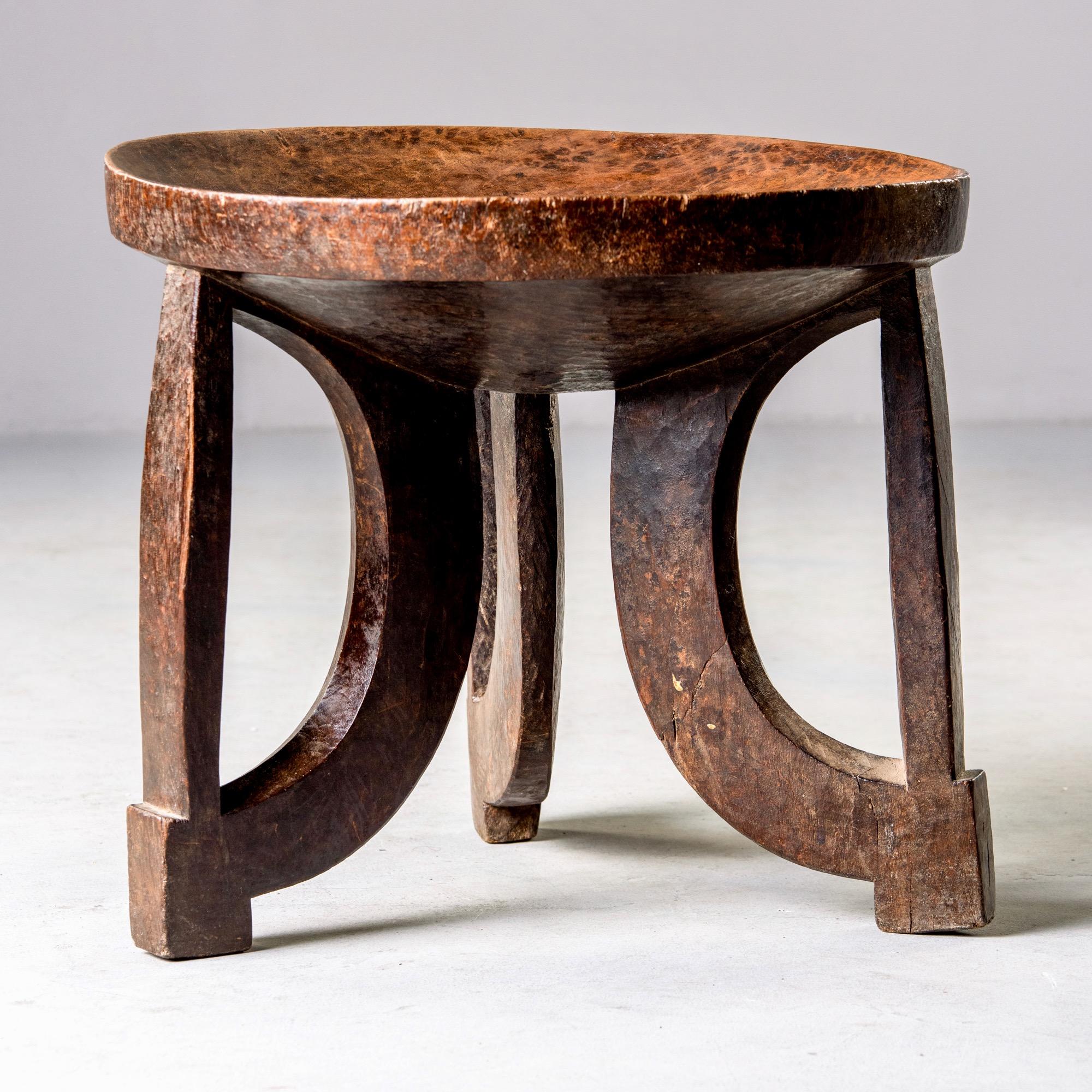 Early 20th century hand carved African tribal stool or table with base of three curved legs and shallow bowl top. Unknown tribal affiliation. This piece is hand carved and is not perfectly symmetrical.