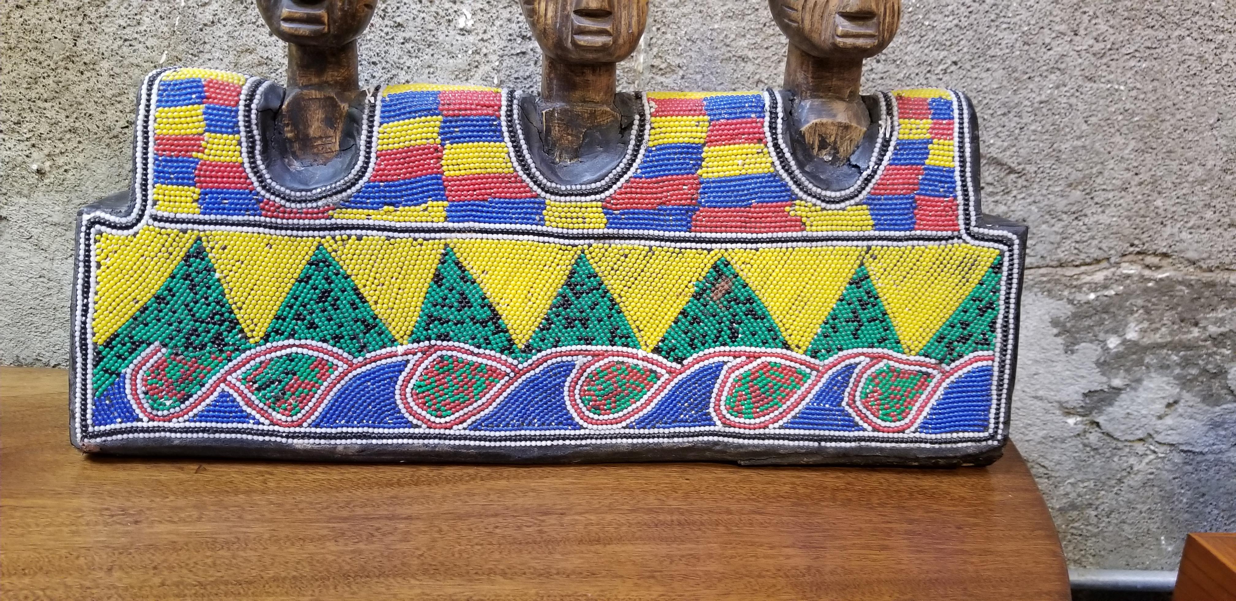 A vintage beaded African wood carving of 3 figures. Vibrant primary colors to bead work. Portions of wood are painted. Attributed to Yoruba, Nigeria, Africa. Mid-late 20th century.

Yoruba Art:
The Yoruba of West Africa (Benin, Nigeria and Togo,