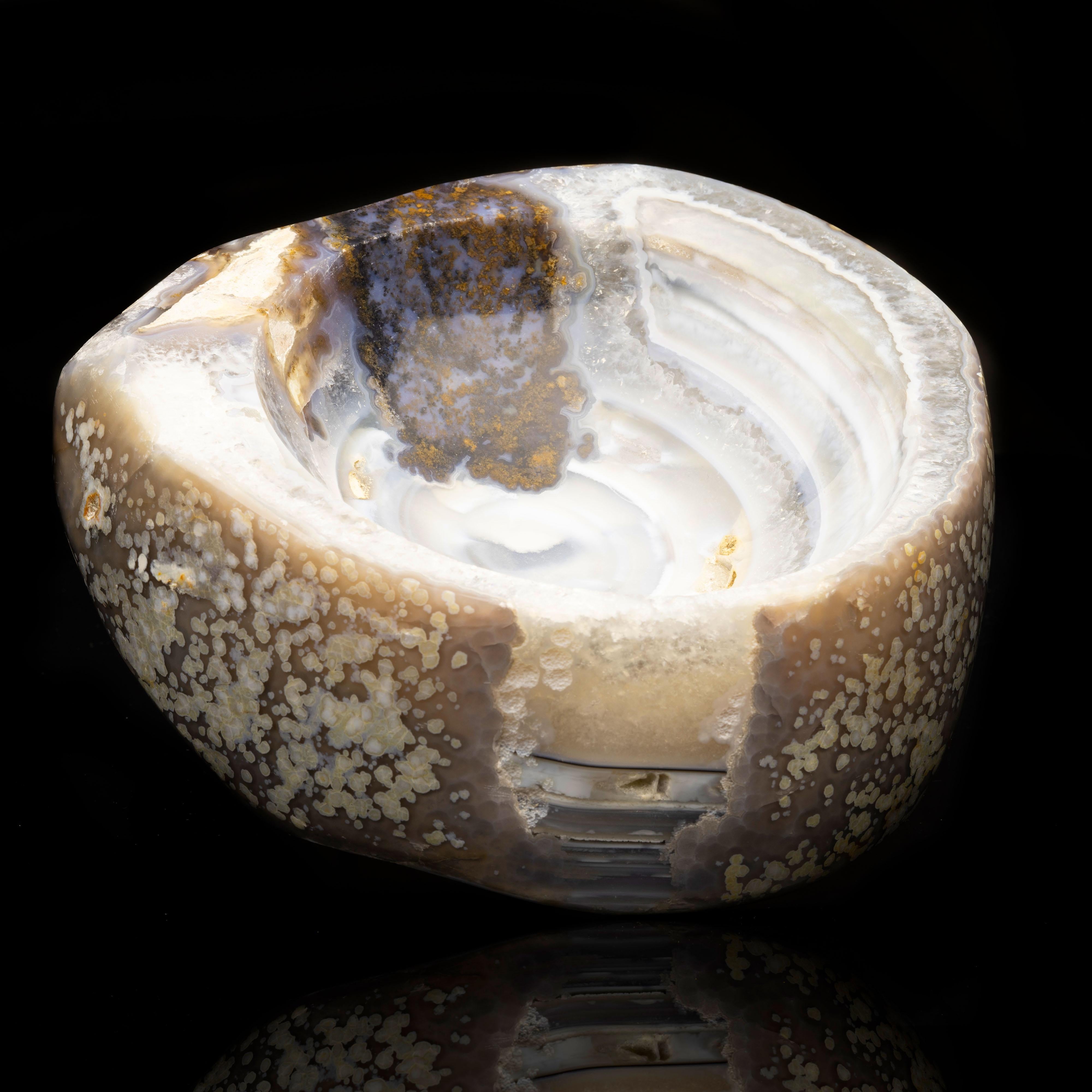 This handsome deep bowl has been hand-carved and hand-polished out of one piece of genuine agate and features concentric blue-gray banding run through with quartz for a beautiful contrast in translucency and texture. The exterior of the bowl is a