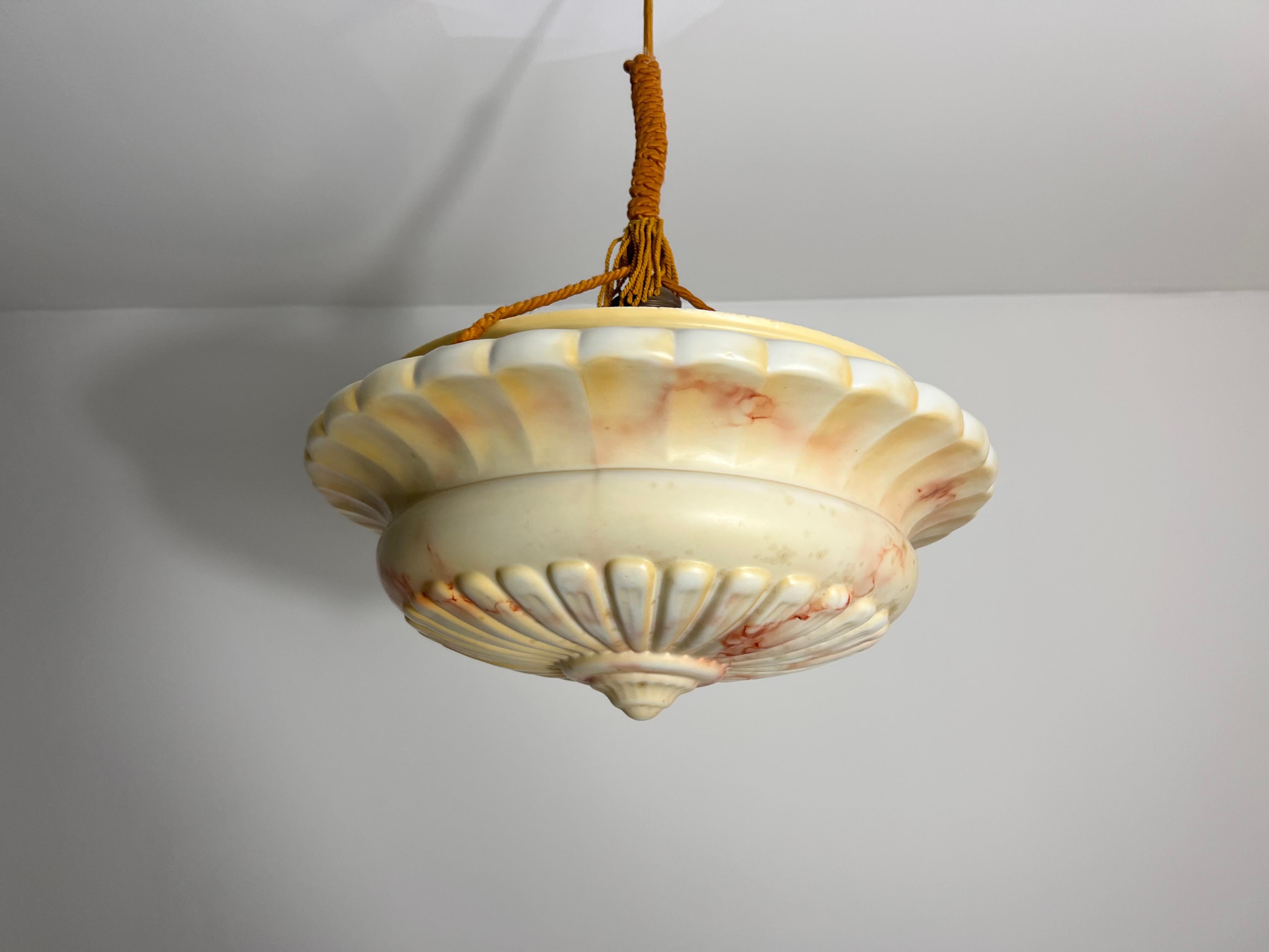 Bellissima lampada a sospensione in alabastro degli anni '30, realizzata in Germania. La luce morbida e diffusa che passa attraverso l'alabastro venato crea un'atmosfera calda e invitante, rendendolo un centrotavola perfetto per qualsiasi stanza. Il