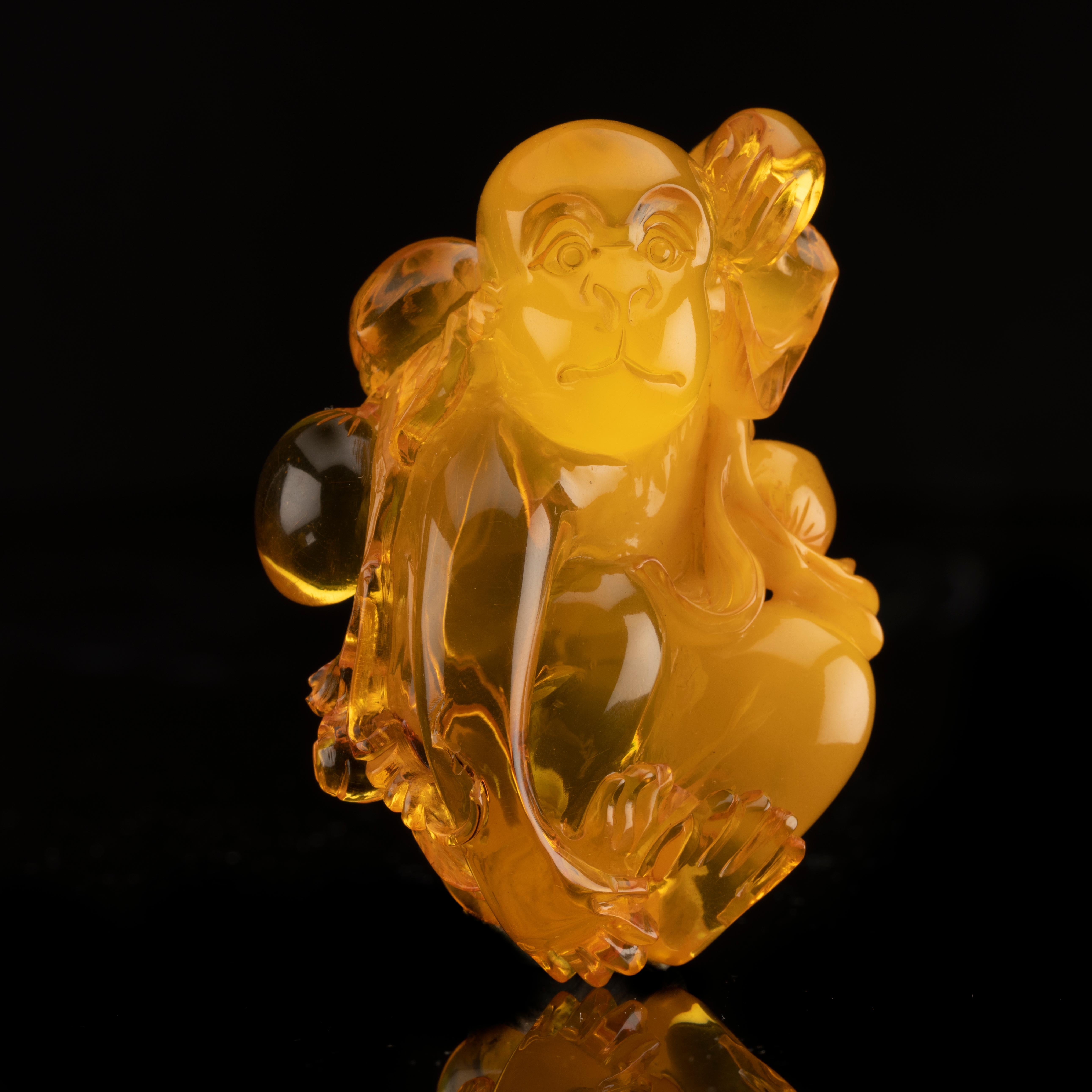 This impressively hand-carved monkey is made out of one piece of excellent quality Baltic amber from Ukraine. He features lovely clarity and luster and exquisite detail. A beautiful addition to any collection. The cube in the picture measures one