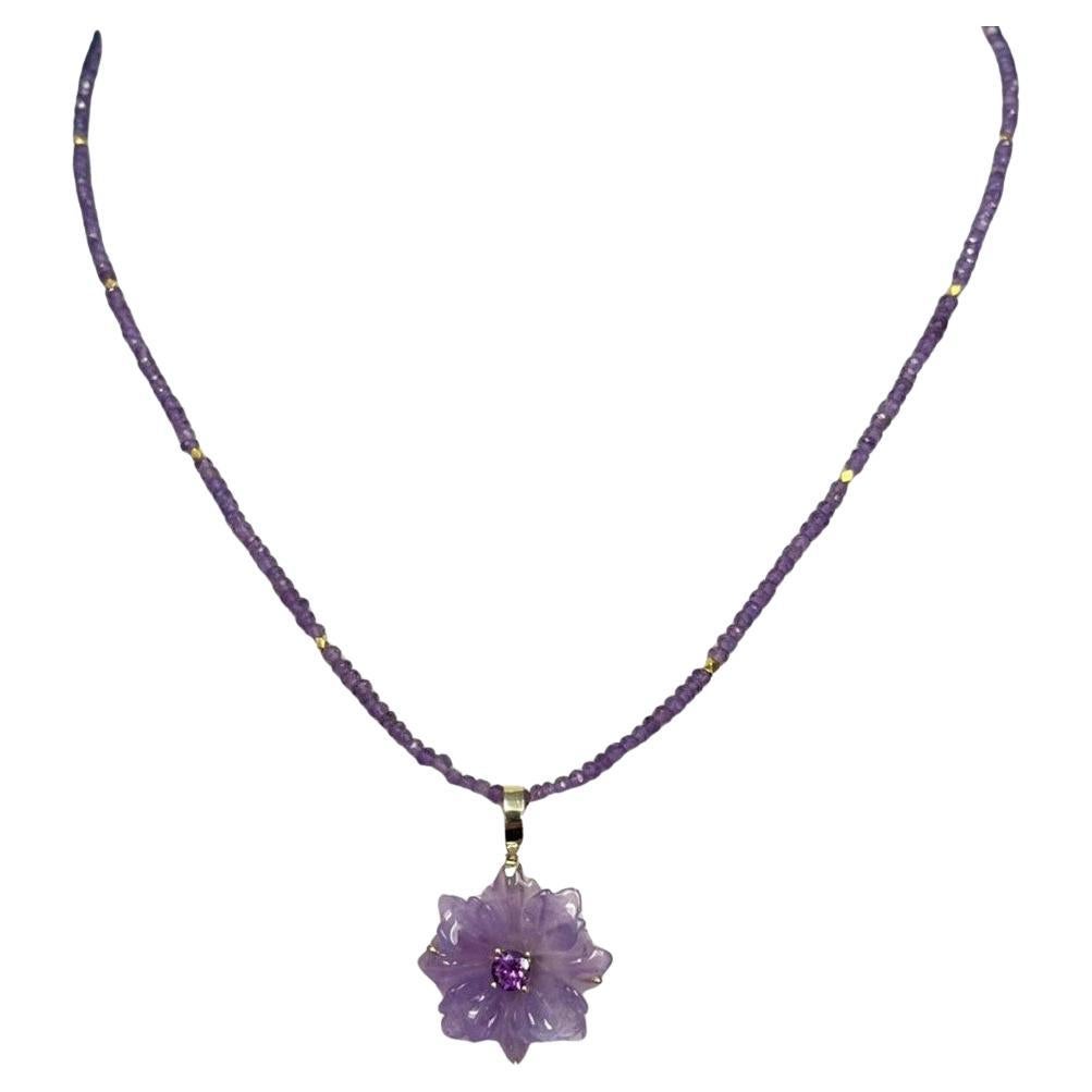 Ce collier unique présente un magnifique pendentif floral en améthyste serti en or jaune 18 carats sur un fil de perles d'améthyste pastel et violet royal. Le pendentif en forme de fleur a été sculpté à la main dans un seul cristal d'améthyste de
