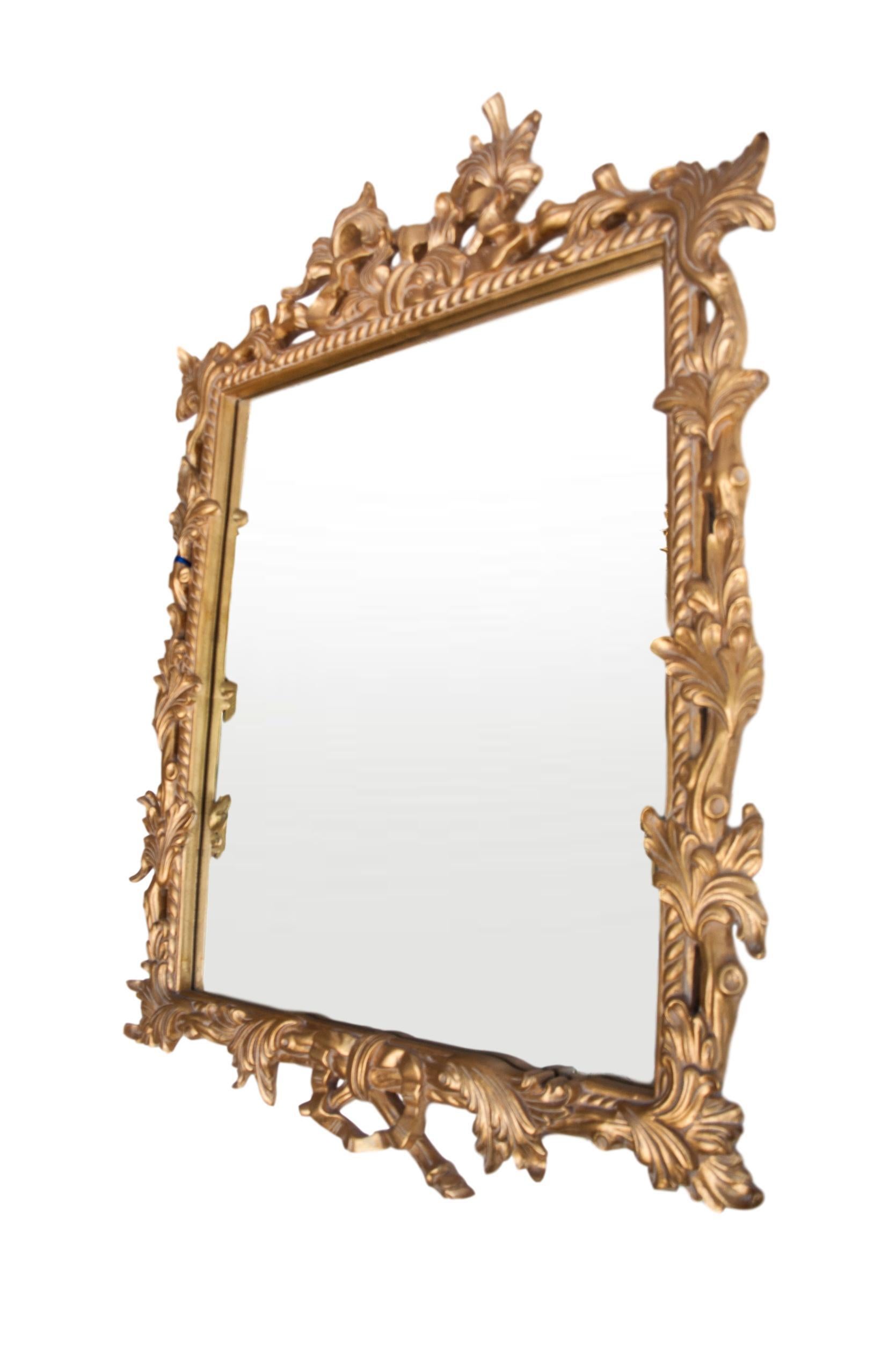 Hand carved and gilded mirror, made in England. This is the highest quality mirror, made to the highest standards of Old Europe, it is gessoed and hand gold leafed. The naturalistic open vine, leaves and free form carving offer an unexpected