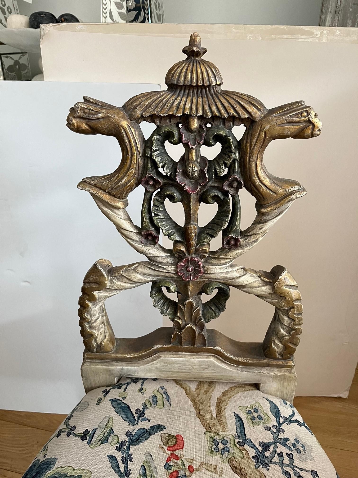 Hand Carved and Antique Hand Painted Finish with Gilded Detailing, Top of Chair foliated with Griffins Heads, Antiqued Brass Nail Head Trim Around the Seat. The Rounded Tapering Legs Curved Inwards in the Middle but splay out Towards the feet, above