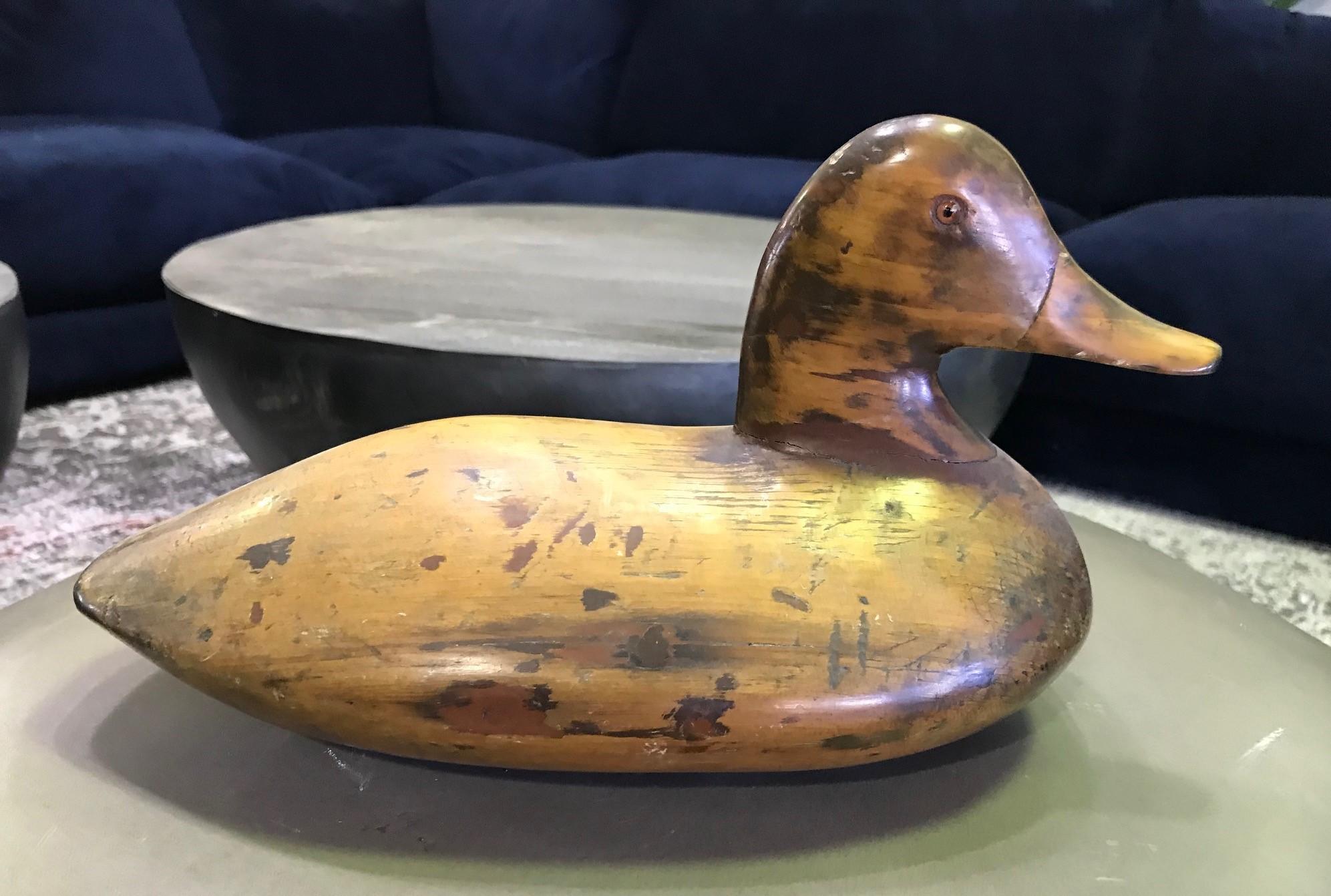 A fantastic early to mid-20th century handmade duck decoy. Beautiful, rich patina that comes with age. Well carved and has what appears to be glass eyes. 

From an extensive collection of vintage /antique duck decoys including a pair by D. W.