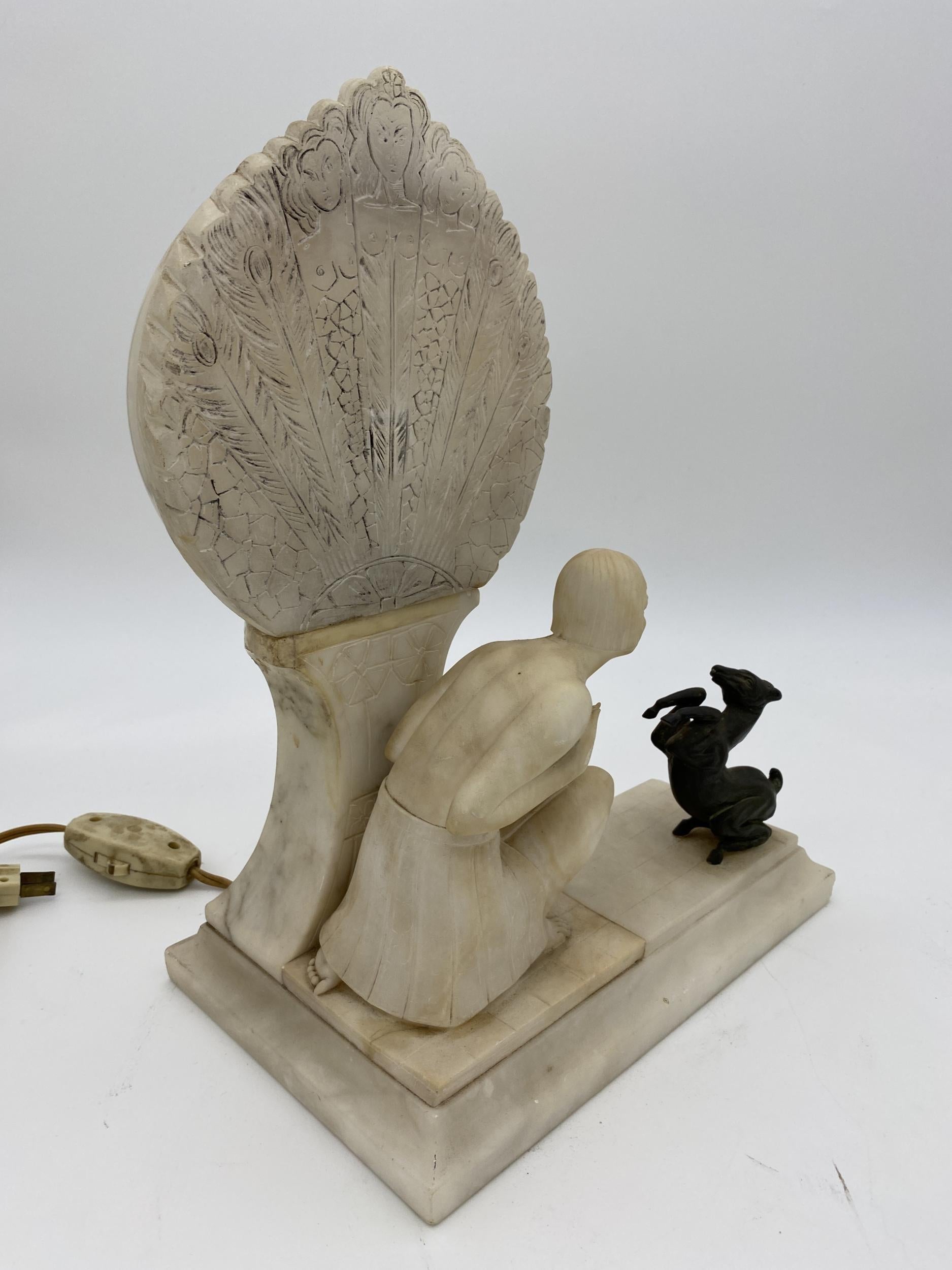 Art Deco period carved alabaster lamp, electrified as the fan is illuminated. Features a women dressed in Flapper clothing, a nude beauty is kneeling to small bronze Gazelle horse. 

 
