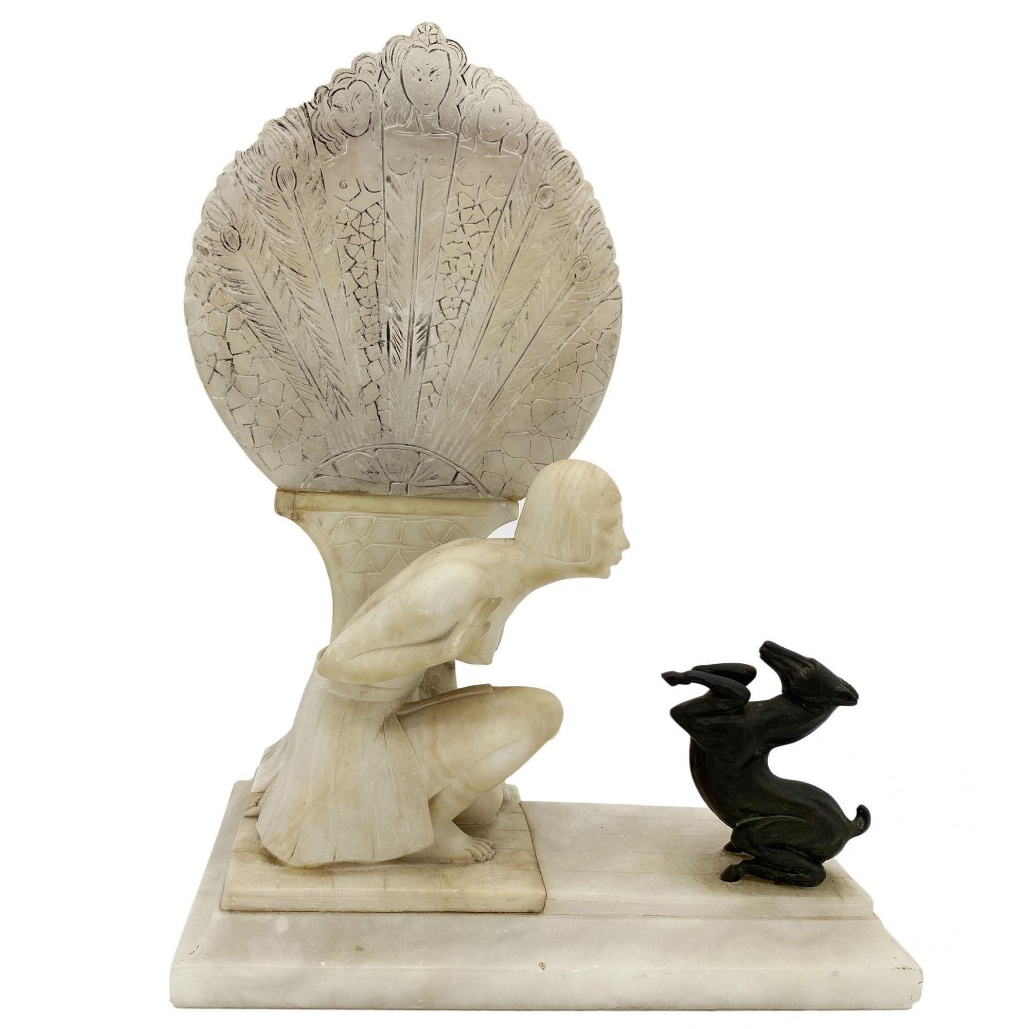 Crafted during the Art Deco period, this electrified alabaster lamp epitomizes sophistication. The softly lit fan complements a flapper-adorned woman in intricate detail, while a kneeling nude beauty accentuates the piece. A masterfully hand-carved
