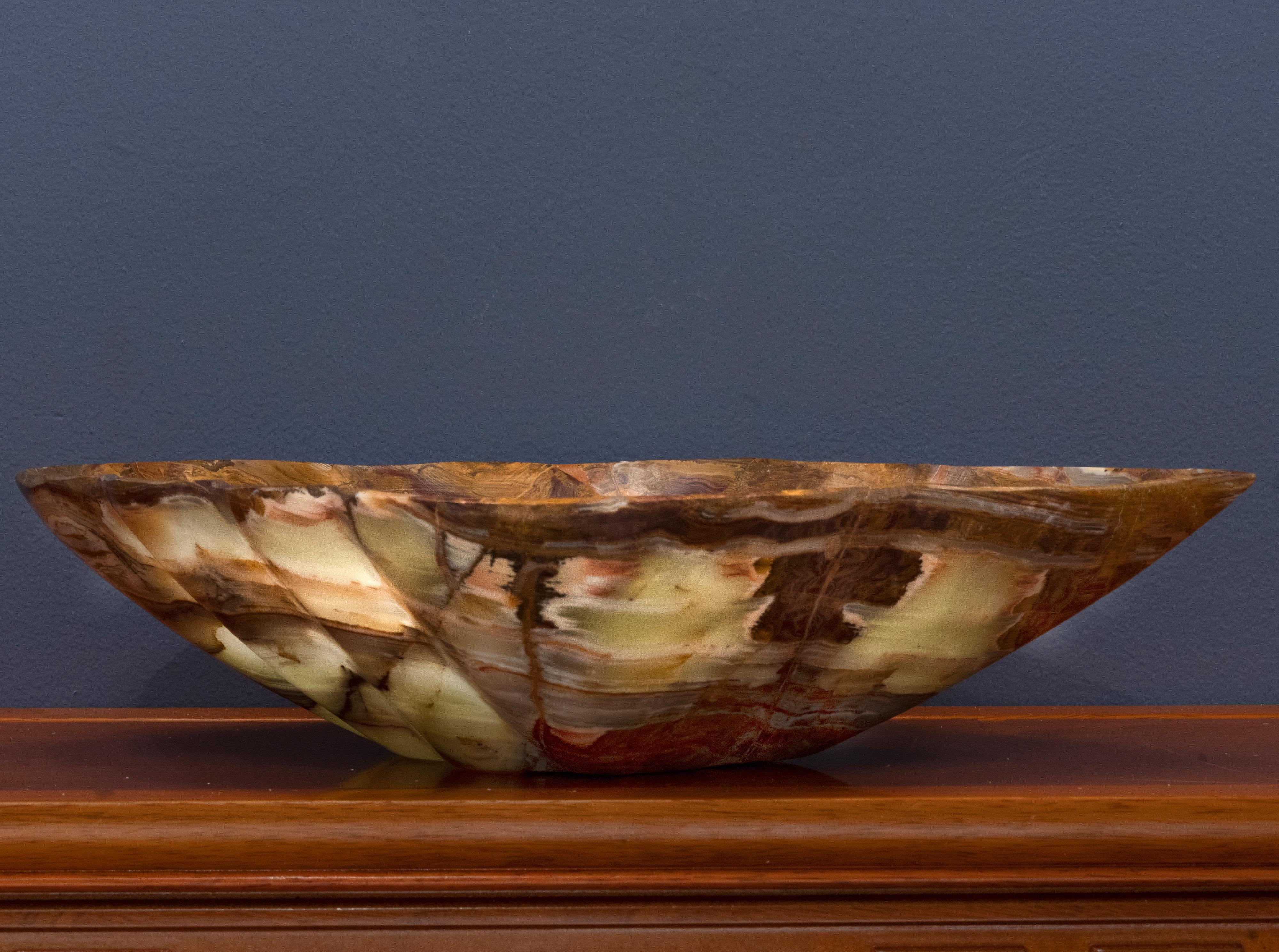 This hand-carved 7.5 pound banded onyx freeform bowl from Pakistan features gorgeously pigmented, earthy banding and veining in shades of brown, green, and tan. A visually arresting way to bring nature into your everyday and onto your dining room