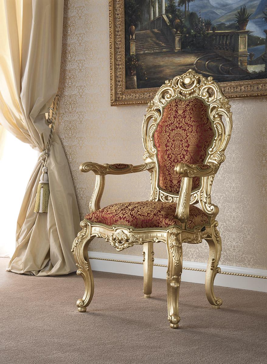 Refurnish your newbuilt mansion with a touch of monarchy by adding one of Modenese Interior's most sold baroque pieces. This dining chair with armrests features wide surfaces of hand-carved squiggle decorations completeley finished with gold-leaf