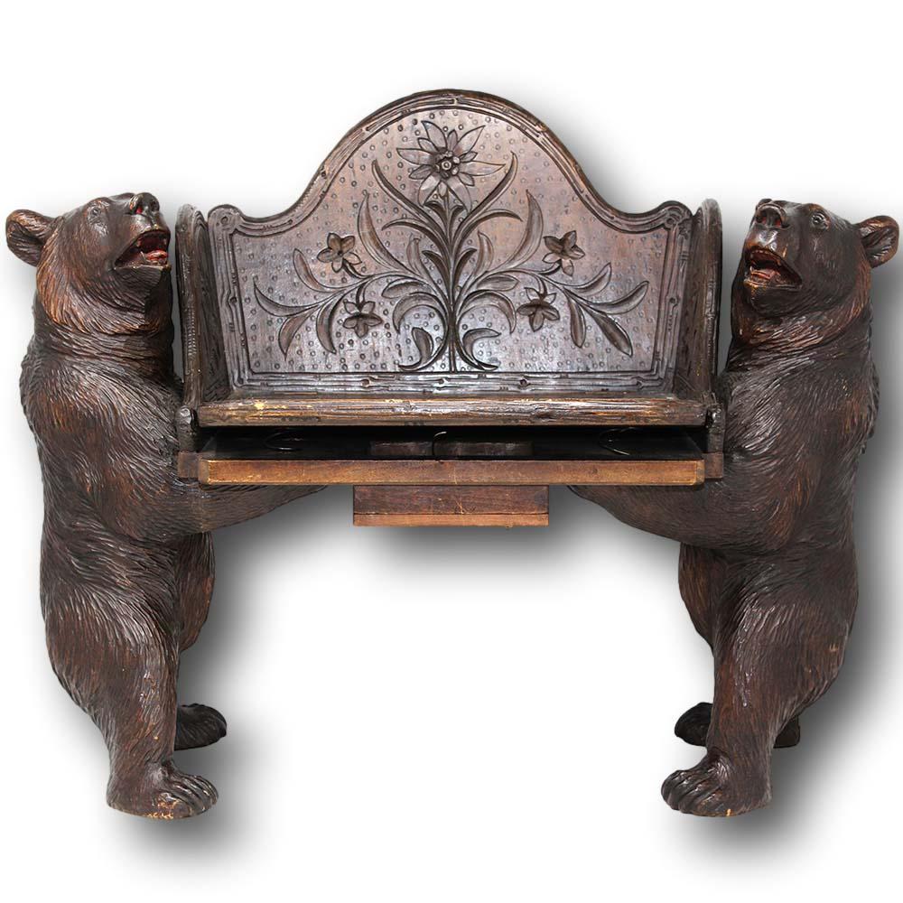 Rare Antique Swiss Black Forest carved musical child's chair circa 1890. The chair of novelty form beautifully carved with a naturalistic look. The chair carved as twin bears supporting the child's seat with open arms full of humorous expressions