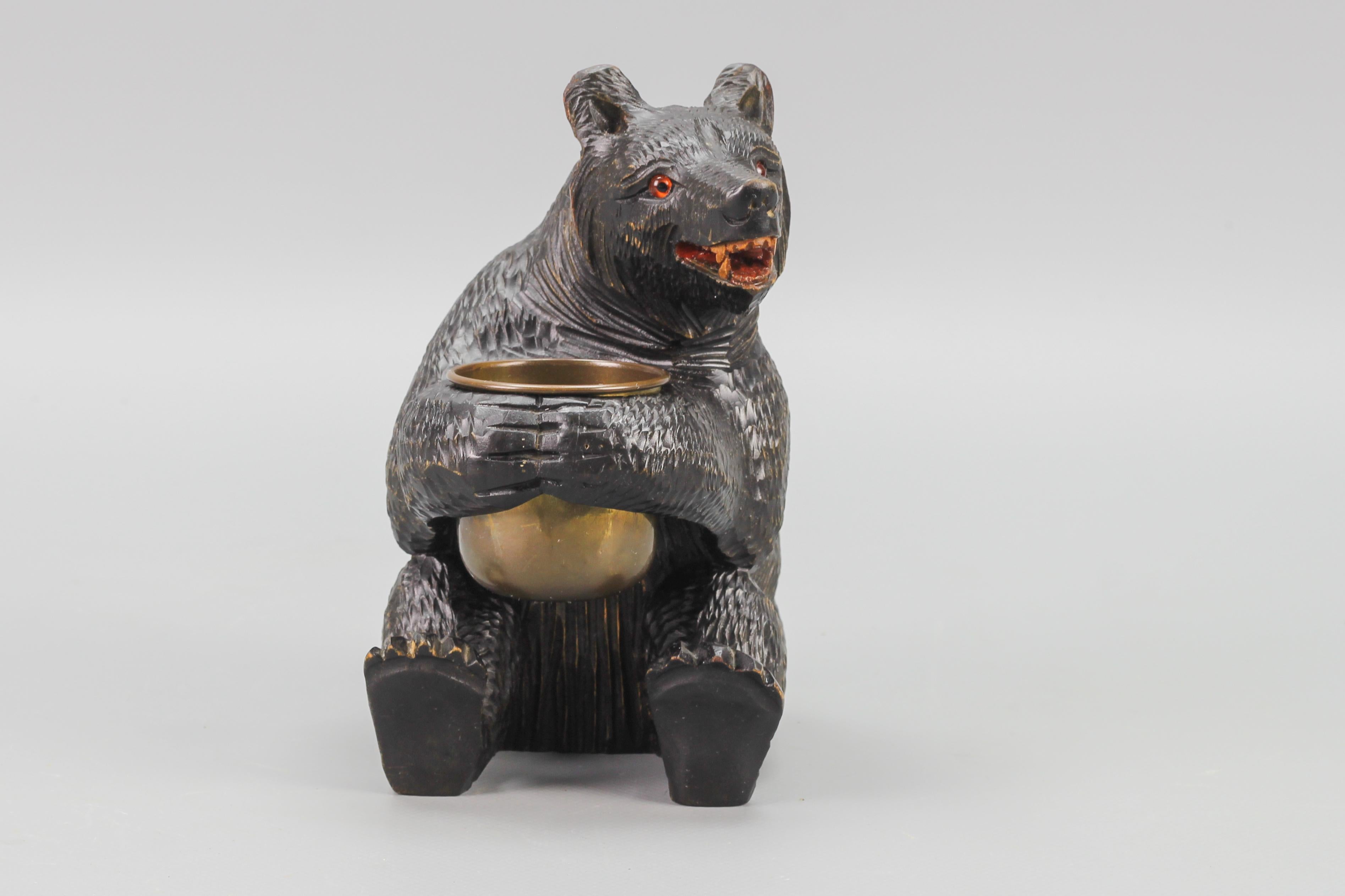 Hand-carved black Forest style bear with a copper pot, from the circa 1920s.
This beautiful hand-carved wooden seated bear is holding a copper pot. Nicely detailed, with glass eyes.
Can be used for the storage of small items on a desk.
Dimensions: