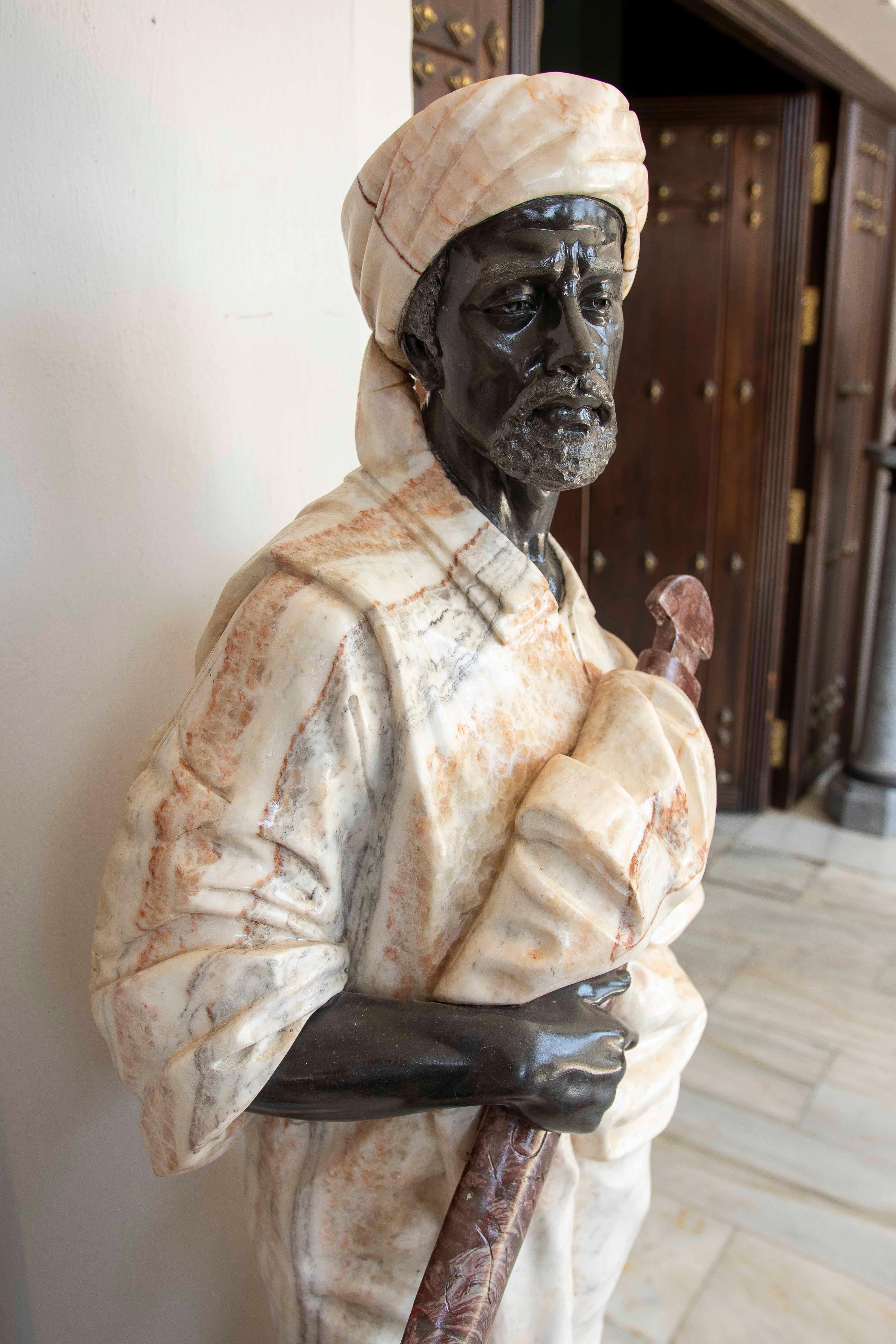 Esta escultura representa a un guerrero de rasgos árabes, tallado íntegramente en mármol mediante una técnica de mármol policromado. La obra combina distintos tipos y colores de mármol, creando un contraste natural sin necesidad de pintura o metales