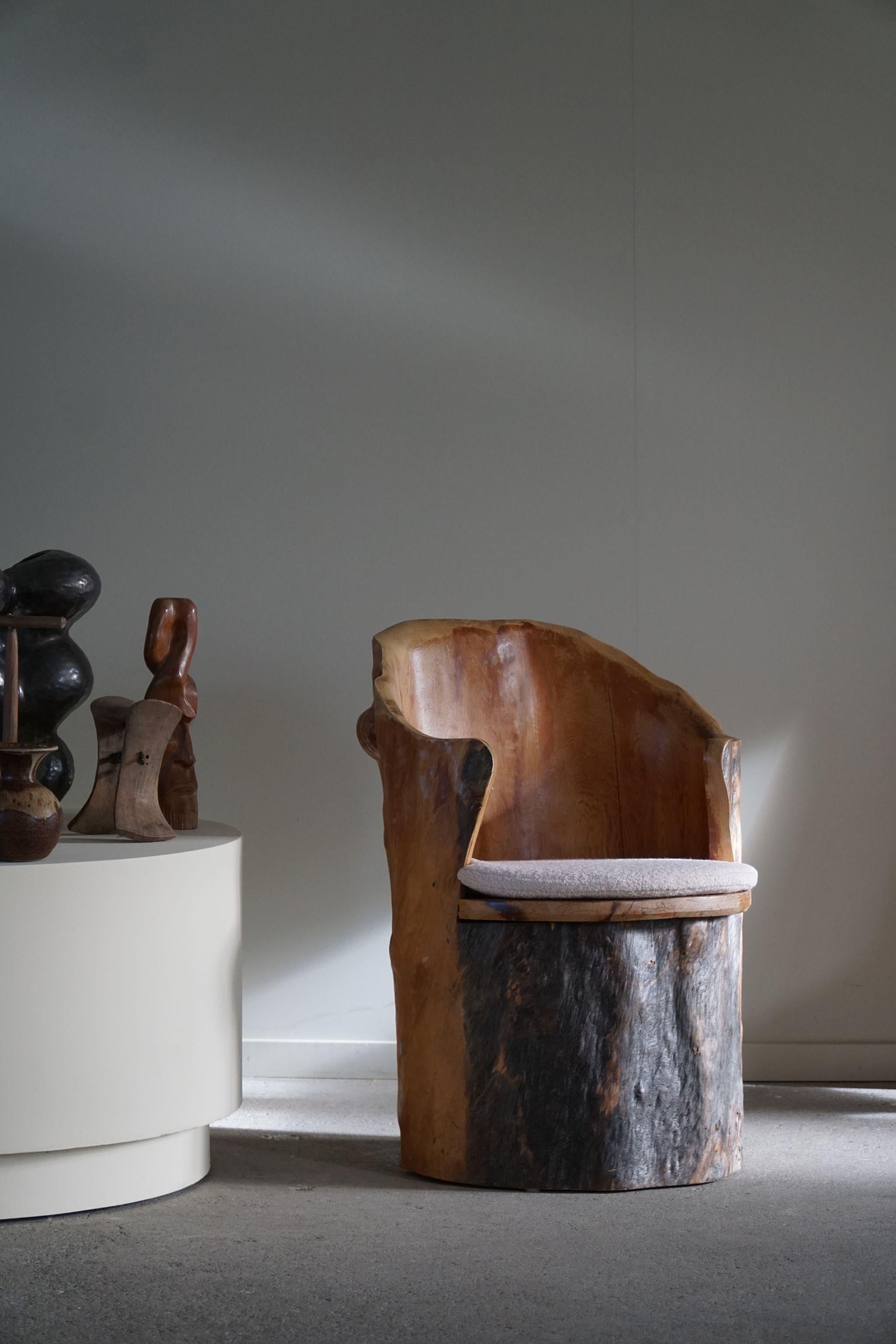 A highly decorative and sculptural stump chair made in solid pine. Hand carved by a Swedish cabinetmaker in the 1970s. Beautiful wood grains and patina in this vintage piece, a truly authentic brutalist piece. Seating in reupholstered bouclé, Tiree