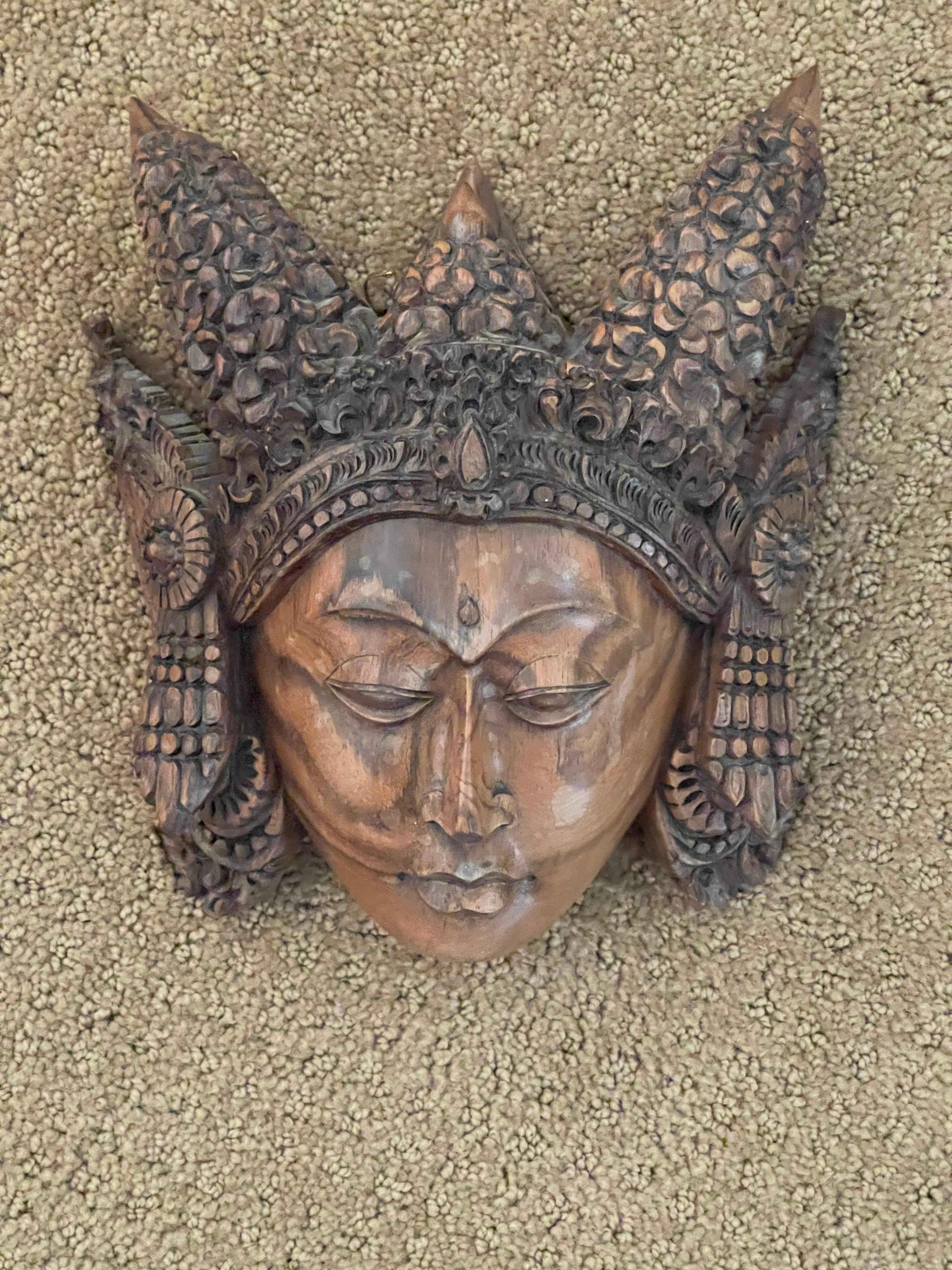 A very cool hand carved wooden buddha head wall plaque from Thailand, circa 1970s. The piece is in very good condition and measures 8