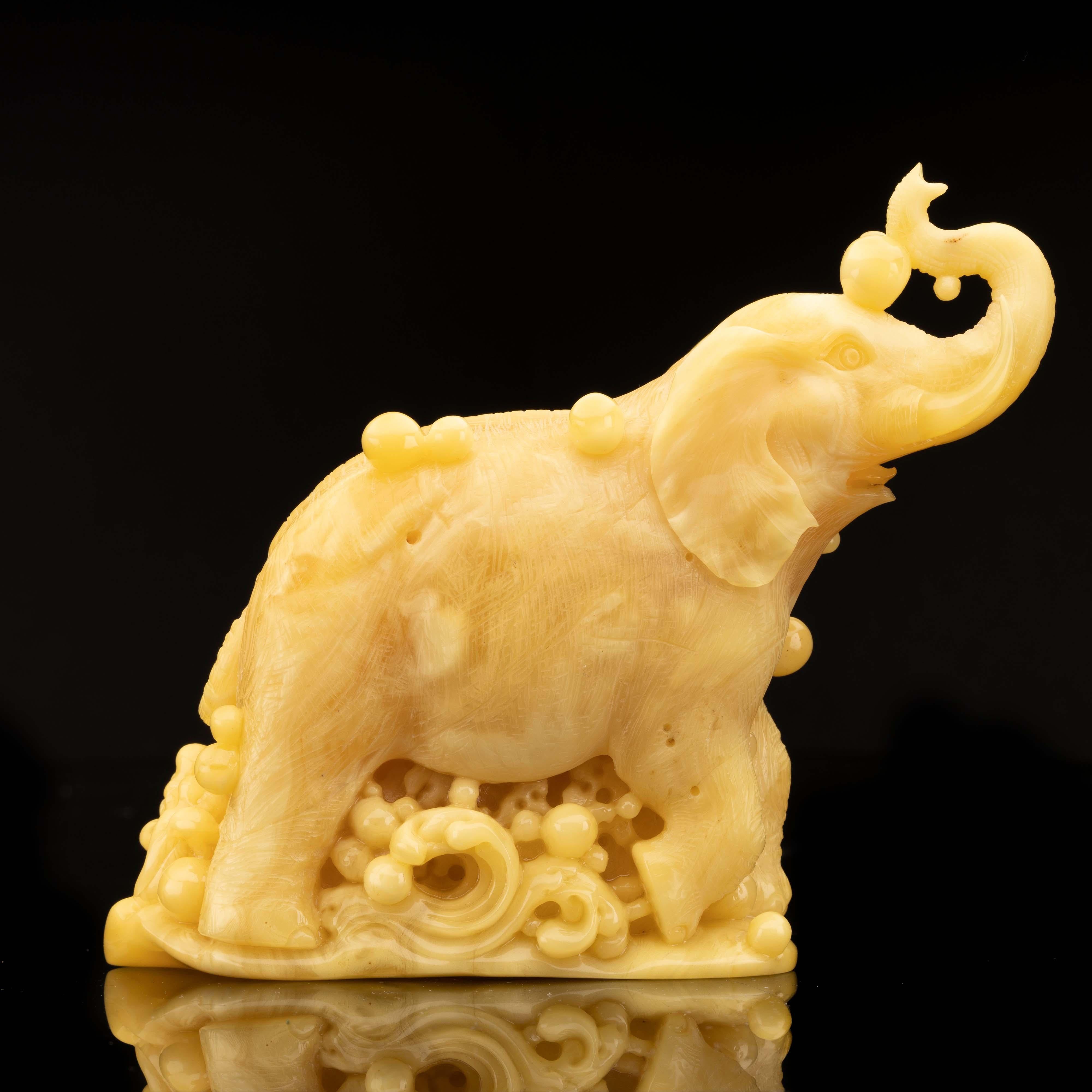 This stunning 200 gram elephant has been hand-carved in exquisite detail from a single piece of excellent quality butterscotch amber from Ukraine. Featuring an upward-facing trunk to usher in luck and prosperity, an intricately tooled baby elephant