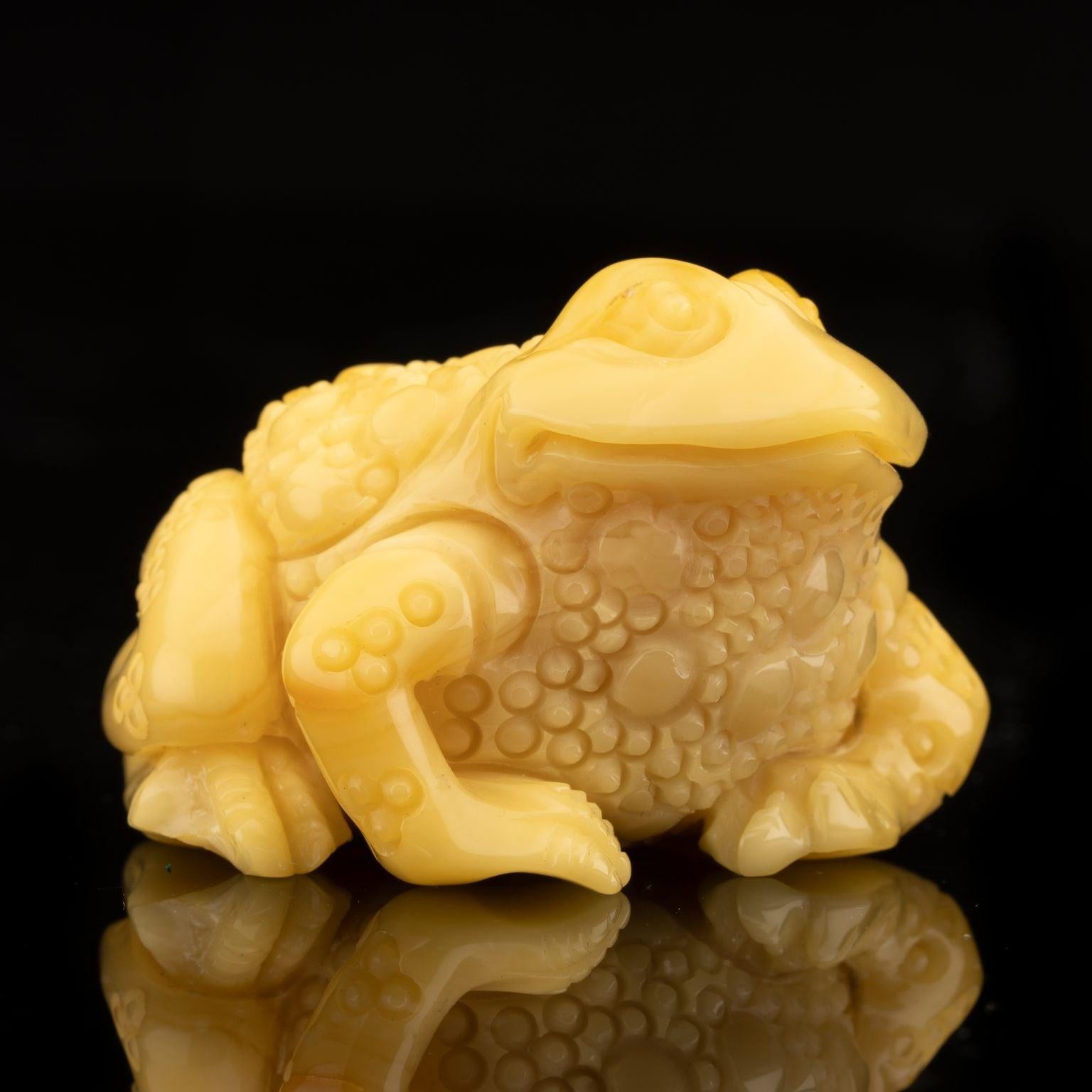 This intricately tooled butterscotch amber frog has been hand-carved from one solid piece of Baltic amber from Ukraine. Featuring exquisite detail, it will make a fantastic addition to your collection. The cube in the picture is one