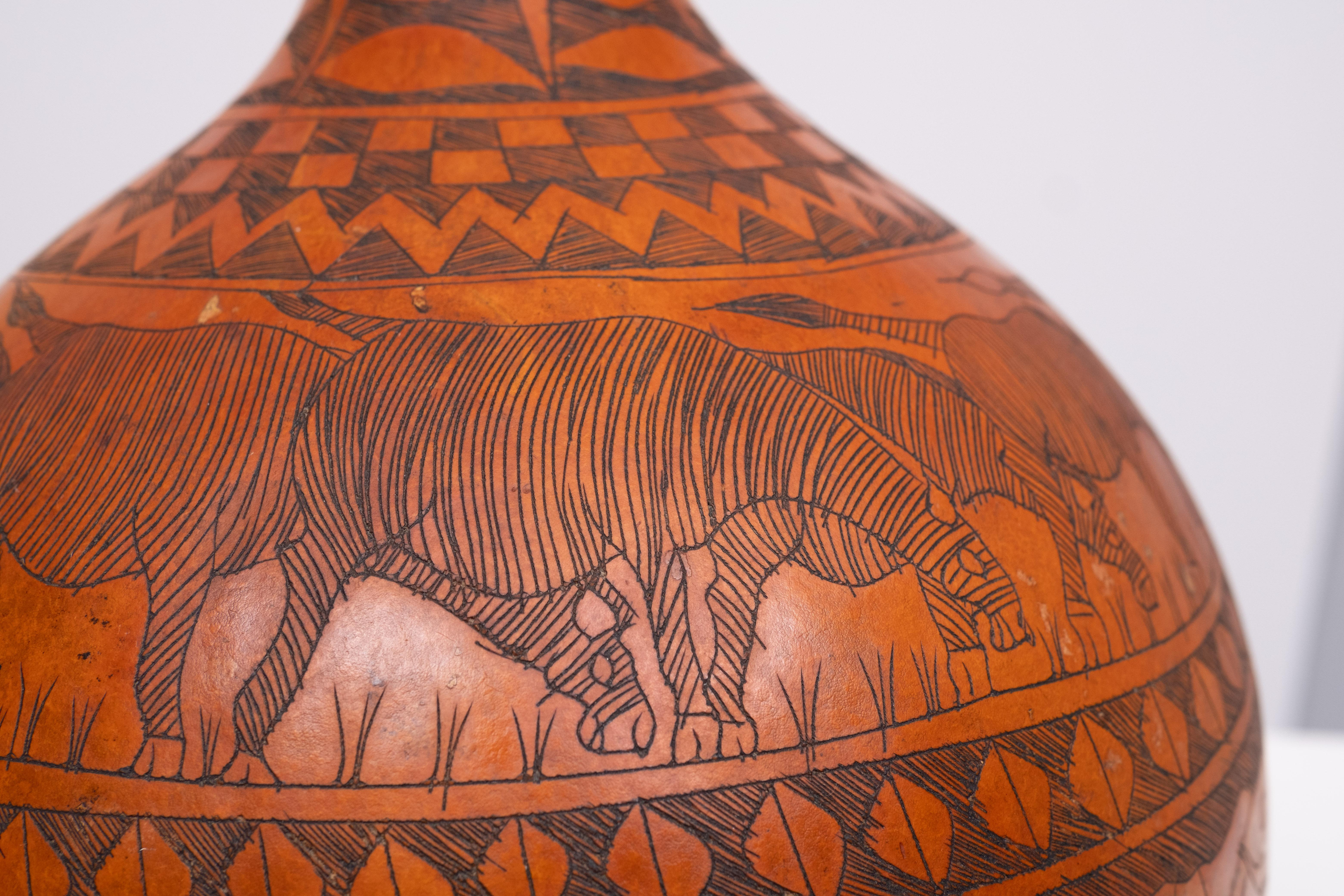 Beautiful hand carved Calabash ,Africa Kenya .   1950s .
Elephants and i think anteaters . Nice warm colors .