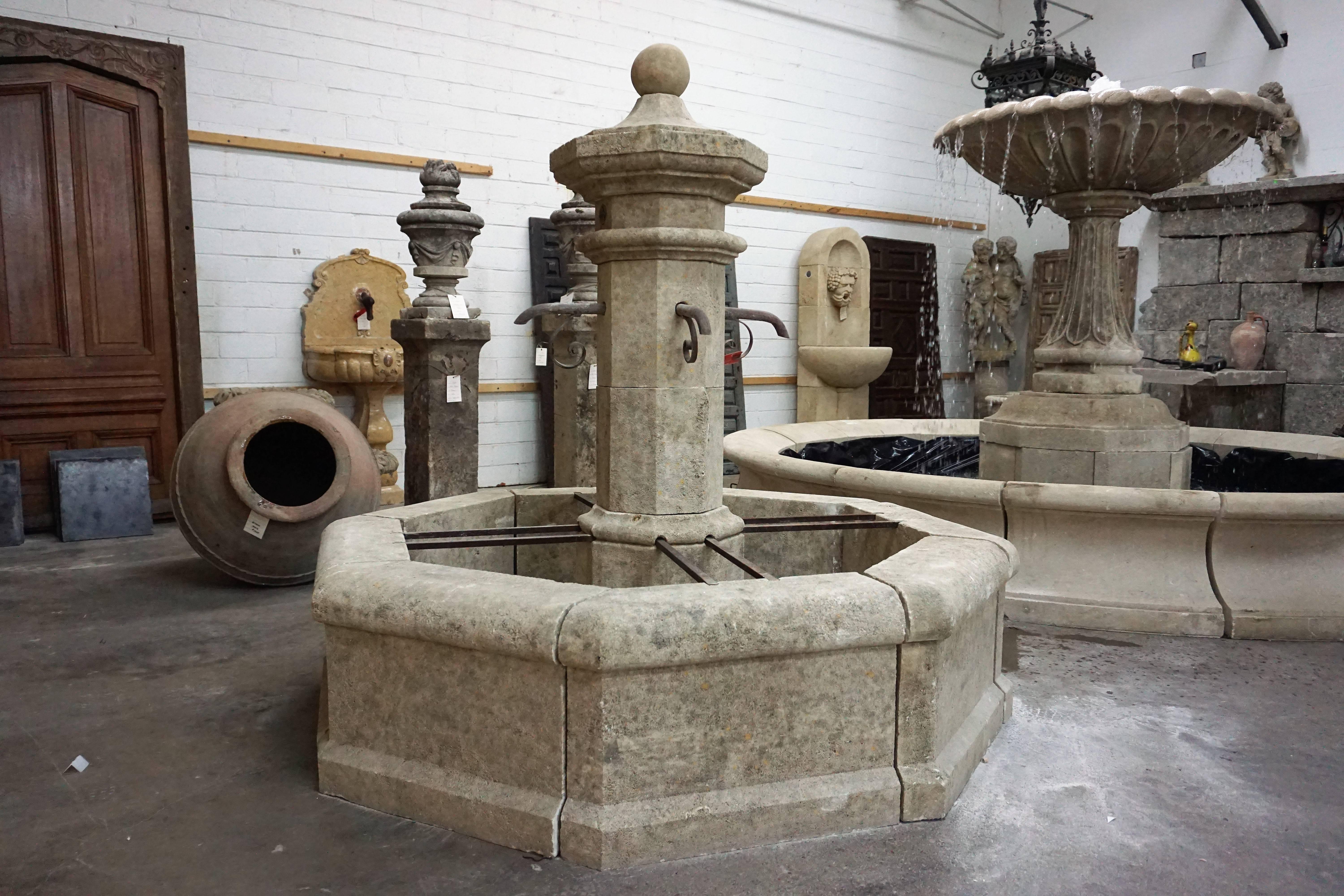 Here we offer a hand carved limestone central fountain with four iron downspouts. This fountain is a classical French design from an antique village fountain reclaimed outside Montpellier, France. The acoustics from this fountain will fill the air
