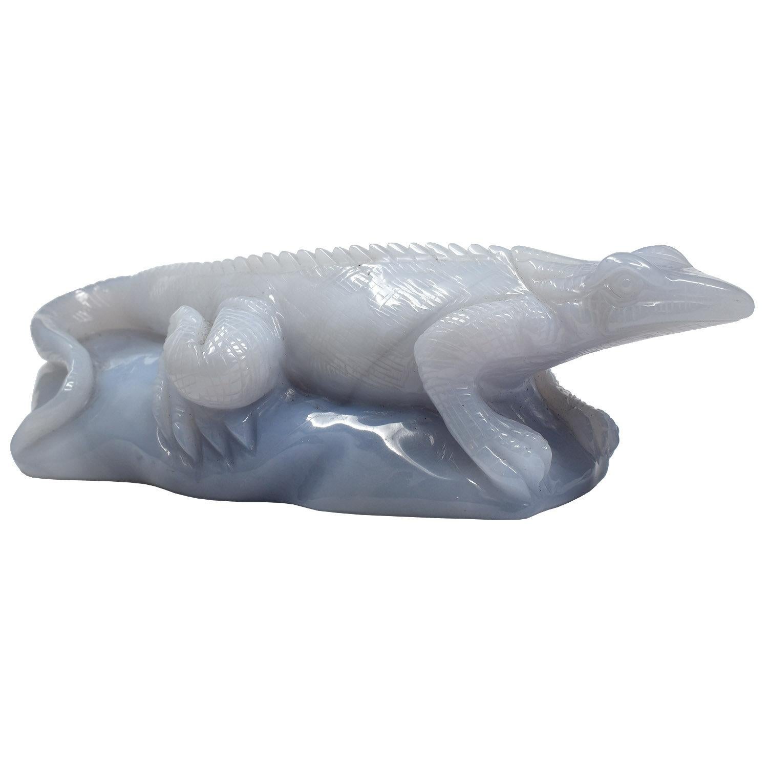 This nicely proportioned, finely carved hardstone sculpture captures these reptiles’ enigmatic, curious presence. The milky blue translucence of the stone adds to the effect. 

Chalcedony is a microcrystalline form of silica, composed of quartz and