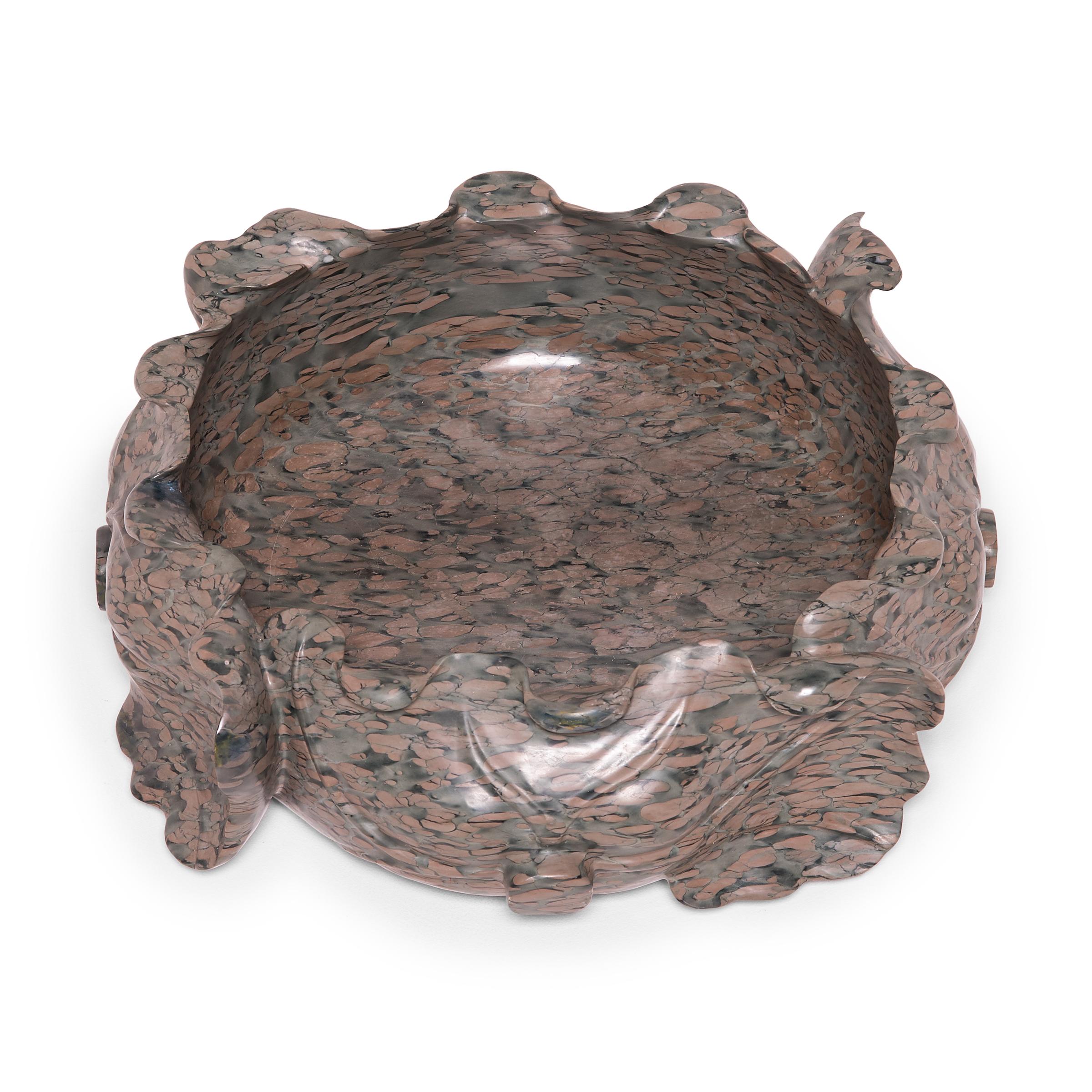 Hand carved of mesmerizing zhenzhu, this contemporary stone basin evokes the graceful shape of a traditional lotus flower. Shaped with undulating curves, the container has the look of freeform pottery. Exploiting the stone’s conglomerate nature to