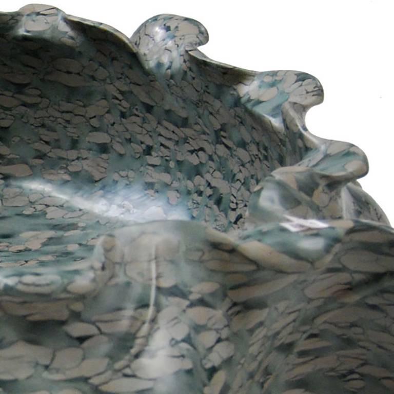 Hand-carved of mesmerizing puddingstone, this contemporary hand-carved stone basin evokes the graceful shape of a traditional lotus flower. Shaped with undulating curves, the container has the look of freeform pottery. Exploiting the stone’s