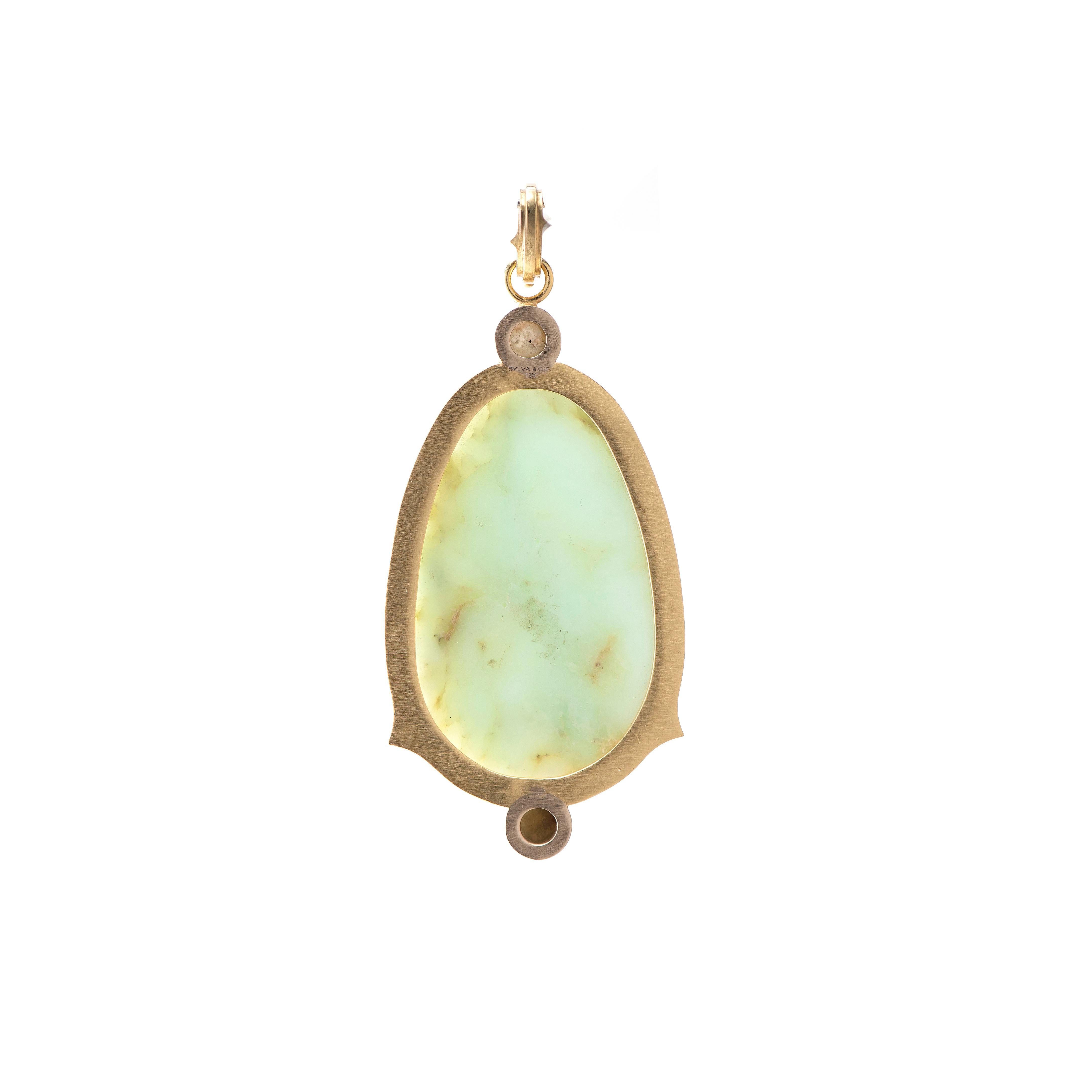 A gorgeous translucent mint green chrysophrase is the focus of this pendant, with a hand-carved snake appearing to swim within the stone.  Framed by two golden rough cut diamonds and a halo of white diamonds with Sylva's signature thorn details,