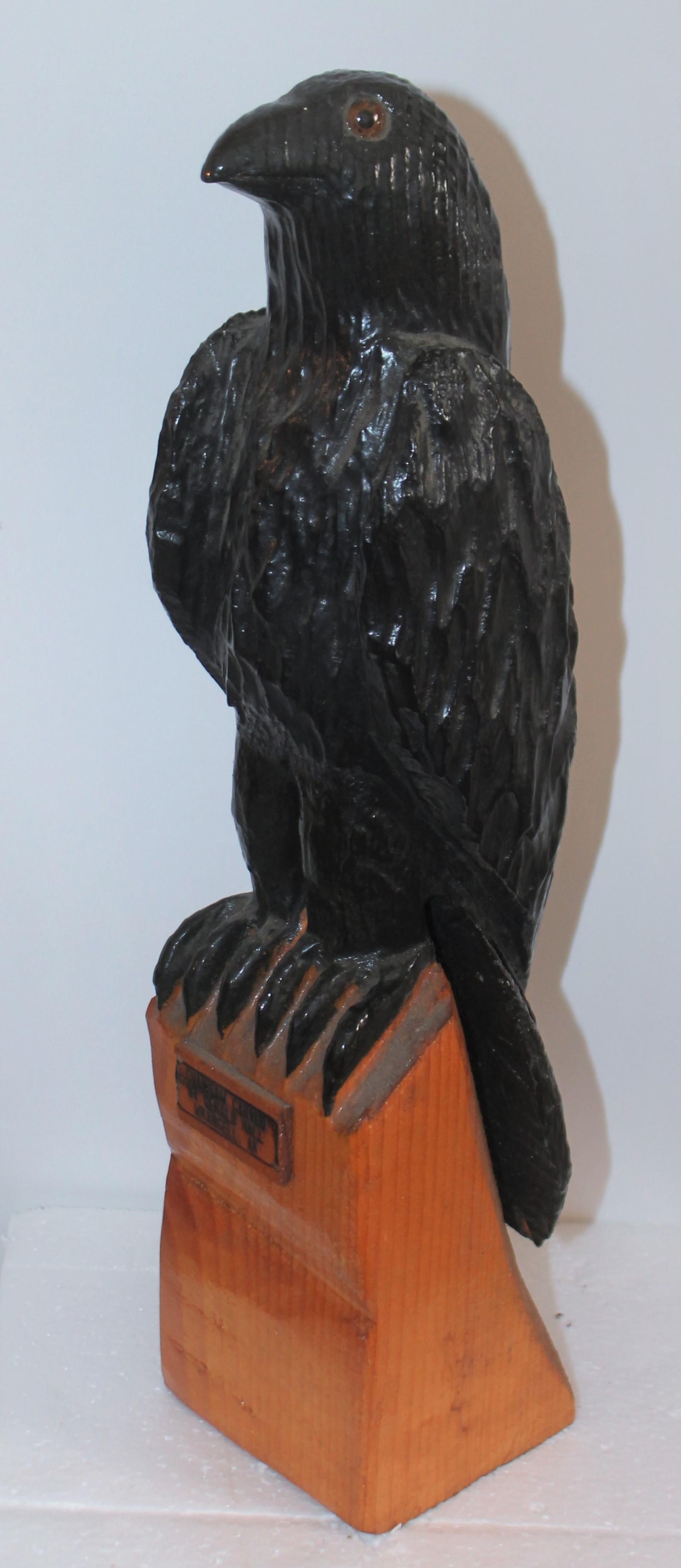 This handmade by Gerald Hall with a chain saw and the crow has glass eyes. The bird is original black paint as well. The condition is very good.