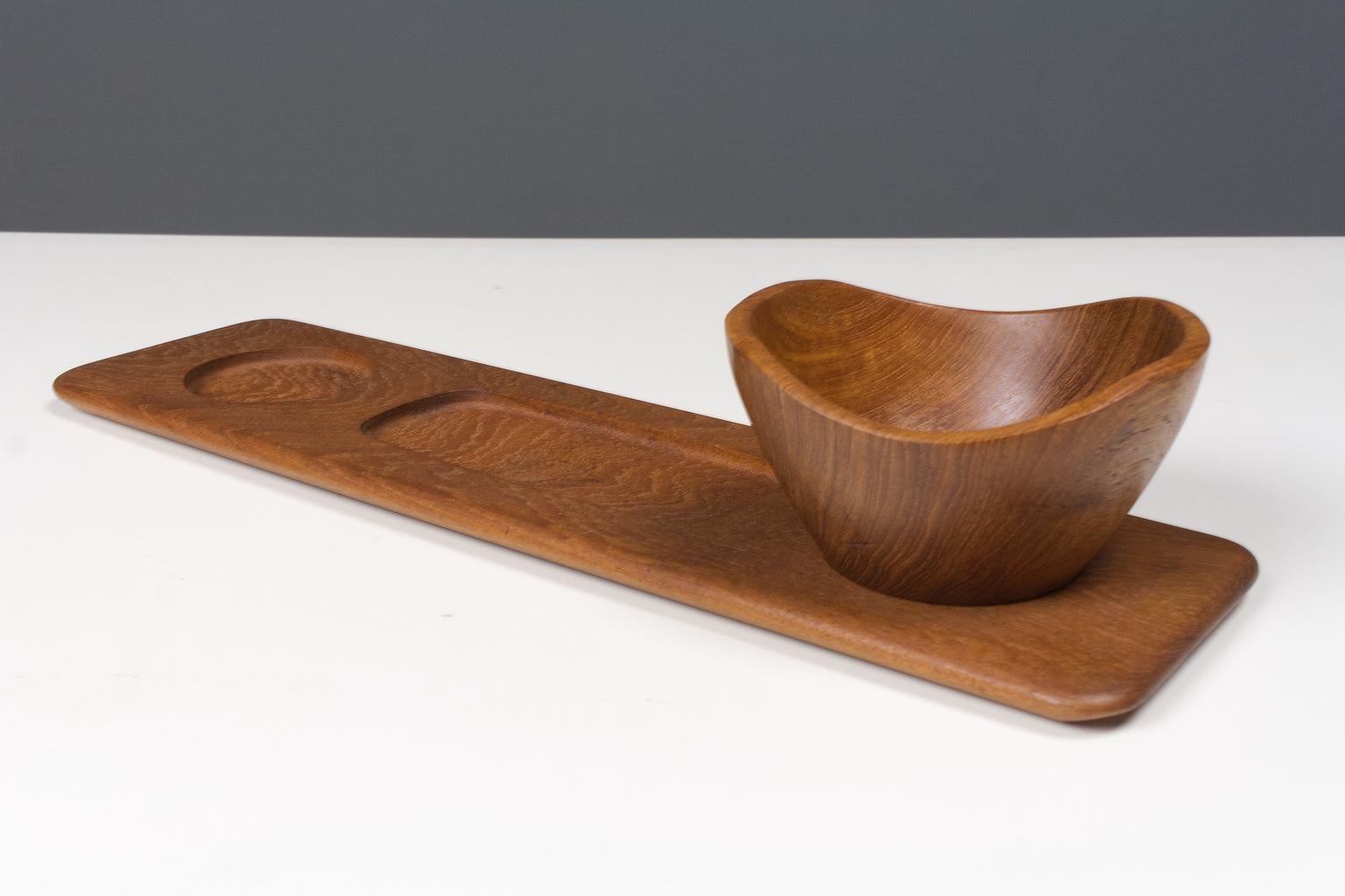 Teak, hand moulded, Danish platter with separate bowl from the 1960s label Digsmed. Brand present. 

This serving plate does no longer have the glass bowls for serving snacks, yet we have added an original danish, asymmetrical hand carved teak