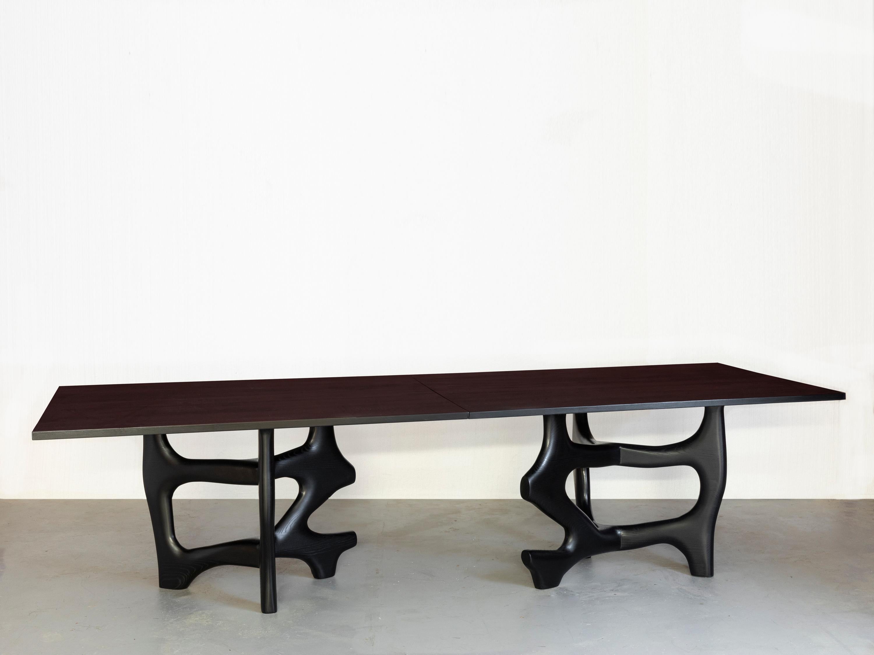 Dieser auffällige Esstisch von Jacques Jarrige ist ein Beweis für seine ständige Erforschung von Form, Volumen und Bewegung. Der aus massiver Eiche handgefertigte und tiefschwarz gebeizte Tisch kombiniert eine elegante, minimalistische Platte mit