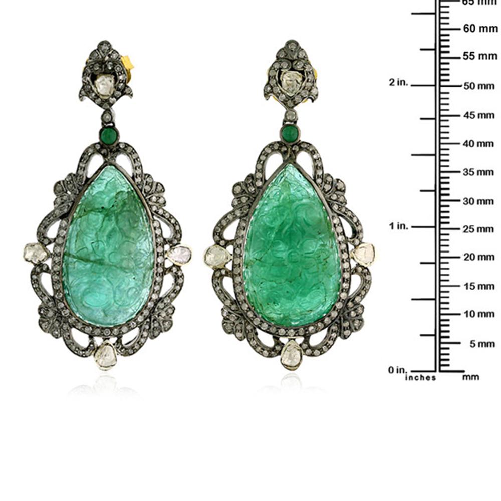 Charming Hand Carved Drop shape Emerald Dangle Earring in 18K Gold and Silver with diamond designer motif around.

Closure: Push Post

18kt Gold:1.65gms
Diamond:3.19cts
Silver:10.99gms
Emerald:60.95cts
