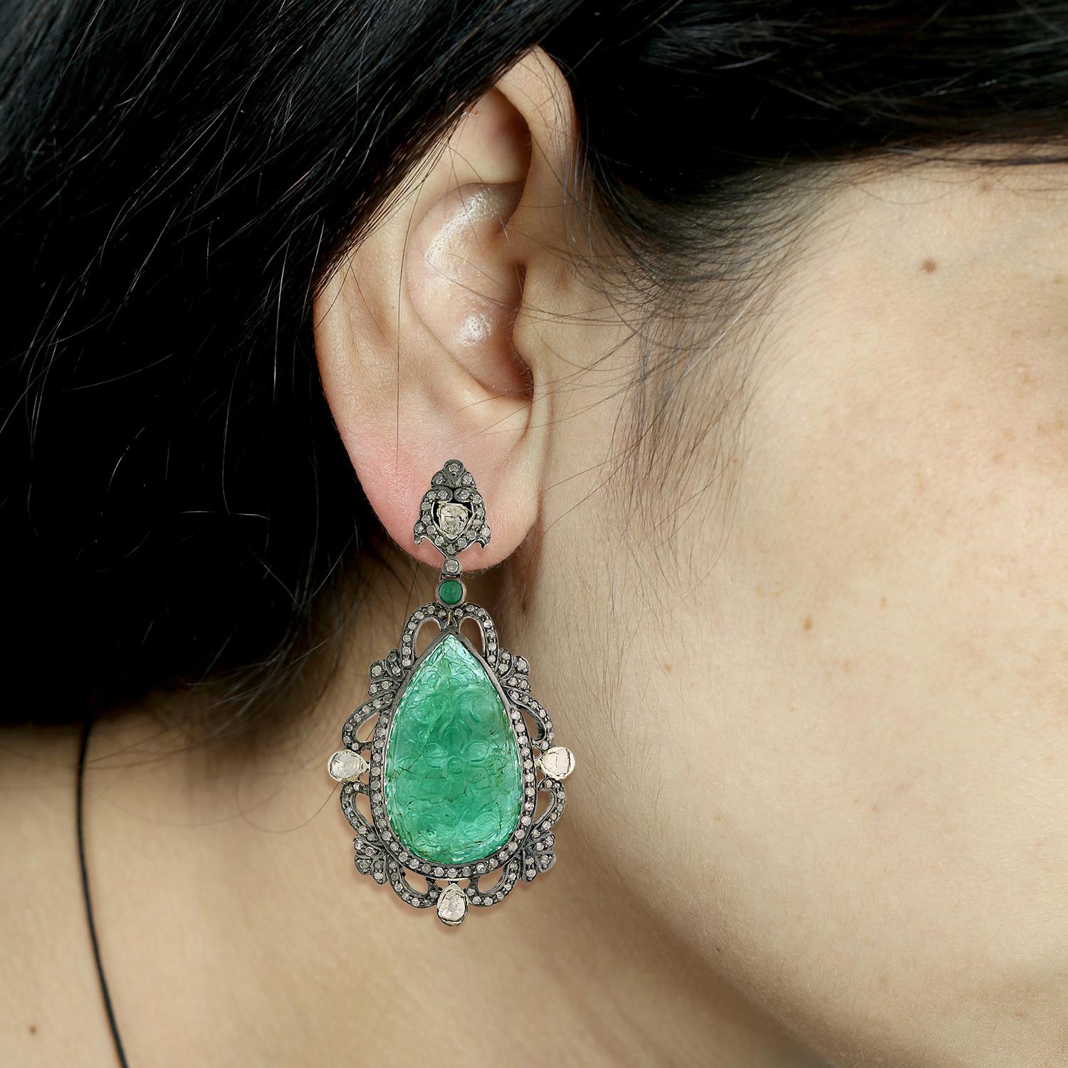 Encantador pendiente colgante de esmeralda tallada a mano en forma de gota en oro de 18 quilates y plata con motivo de diseño de diamantes alrededor.

Cierre: Poste de empuje

18kt Gold:1.65gms
Diamond:3.19cts
Silver:10.99gms
Emerald:60.95cts
