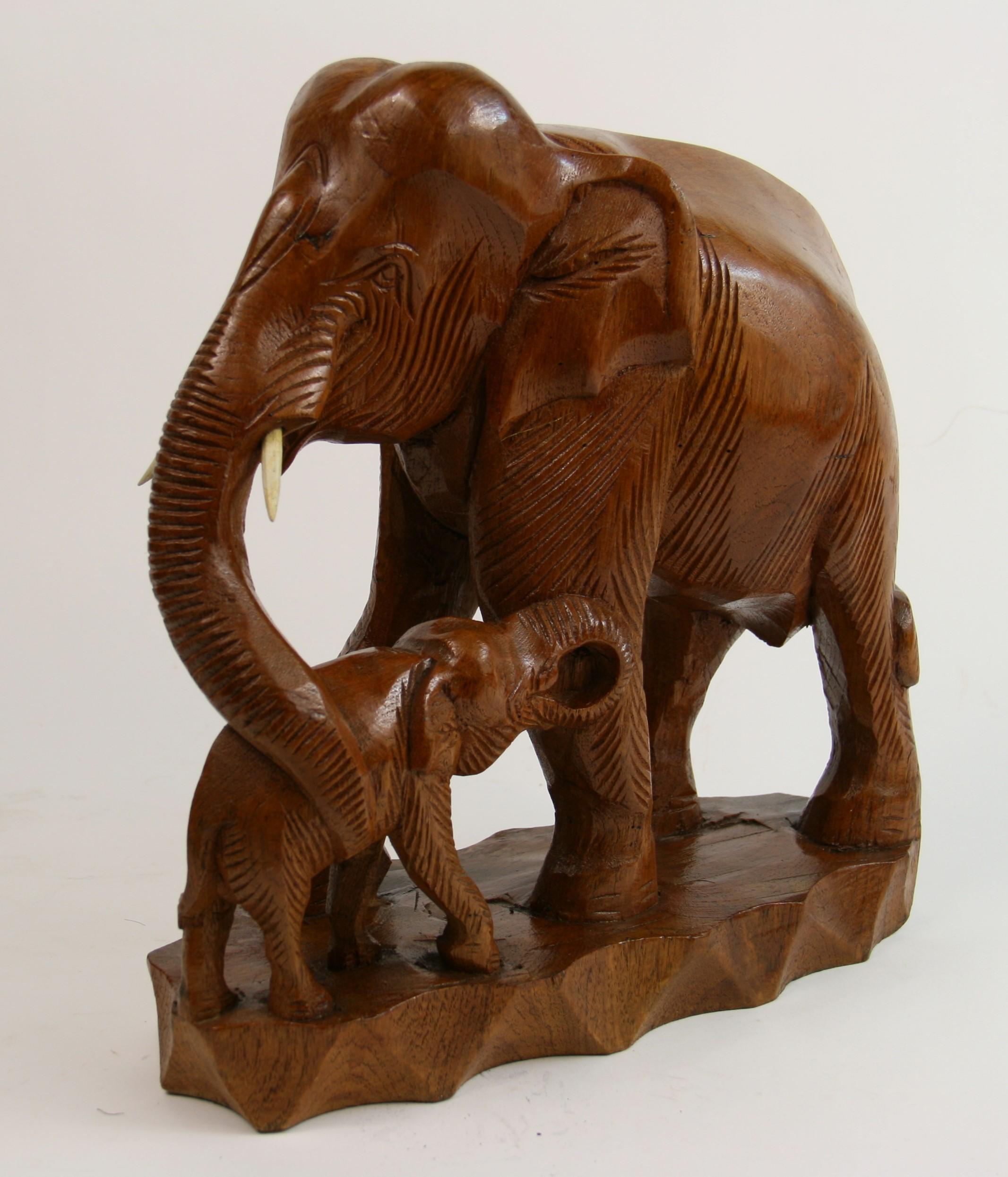 2-294, hand carved sculpture from a solid block of hardwood depicting a large elephant cradling a baby
Beautiful details in the carving.