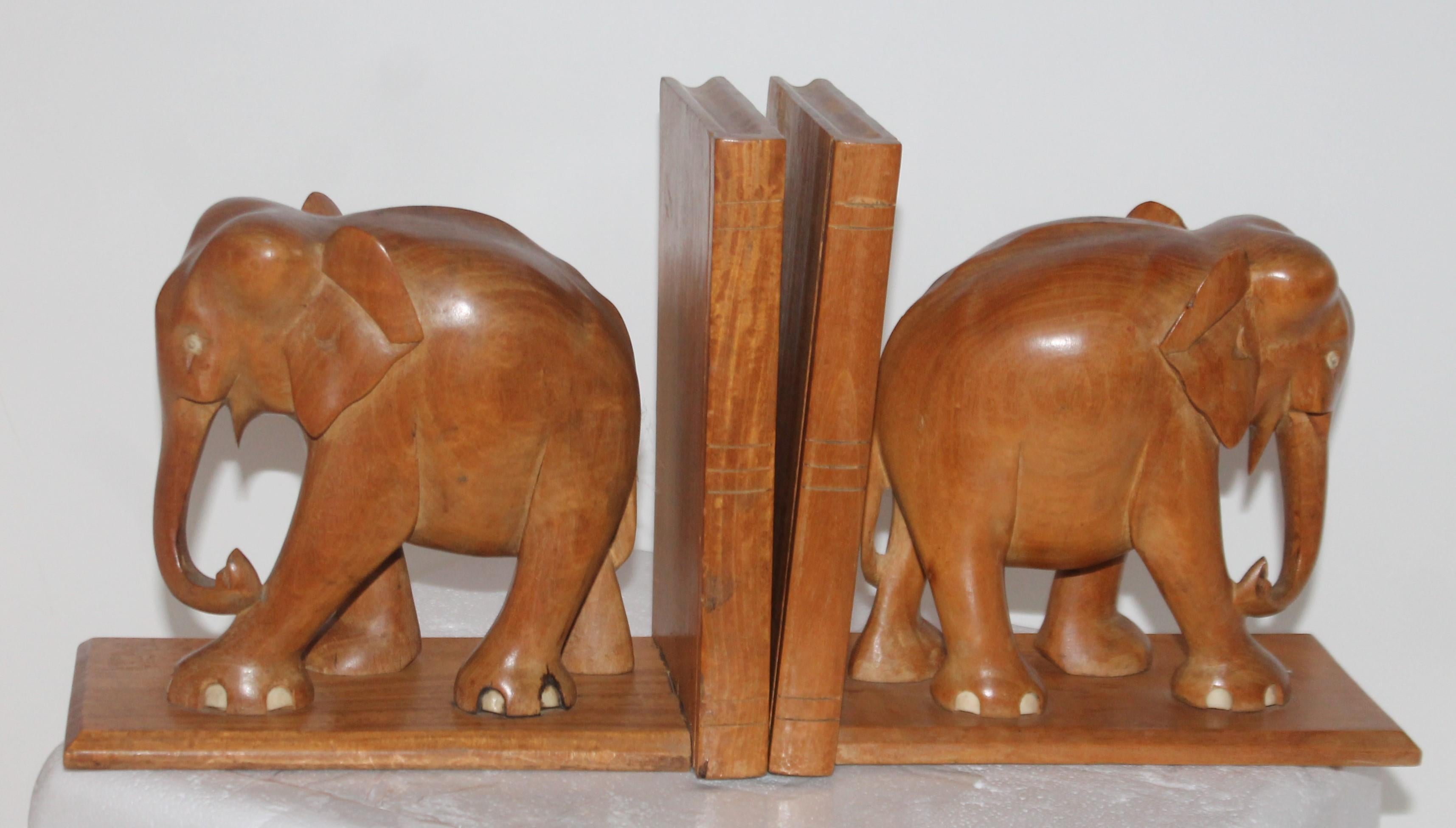 This fine detailed hand carved elephant bookends with inlaid bone eyes and toes. The construction of the wood bases are all hand dovetailed. They are very well carved and heavy.