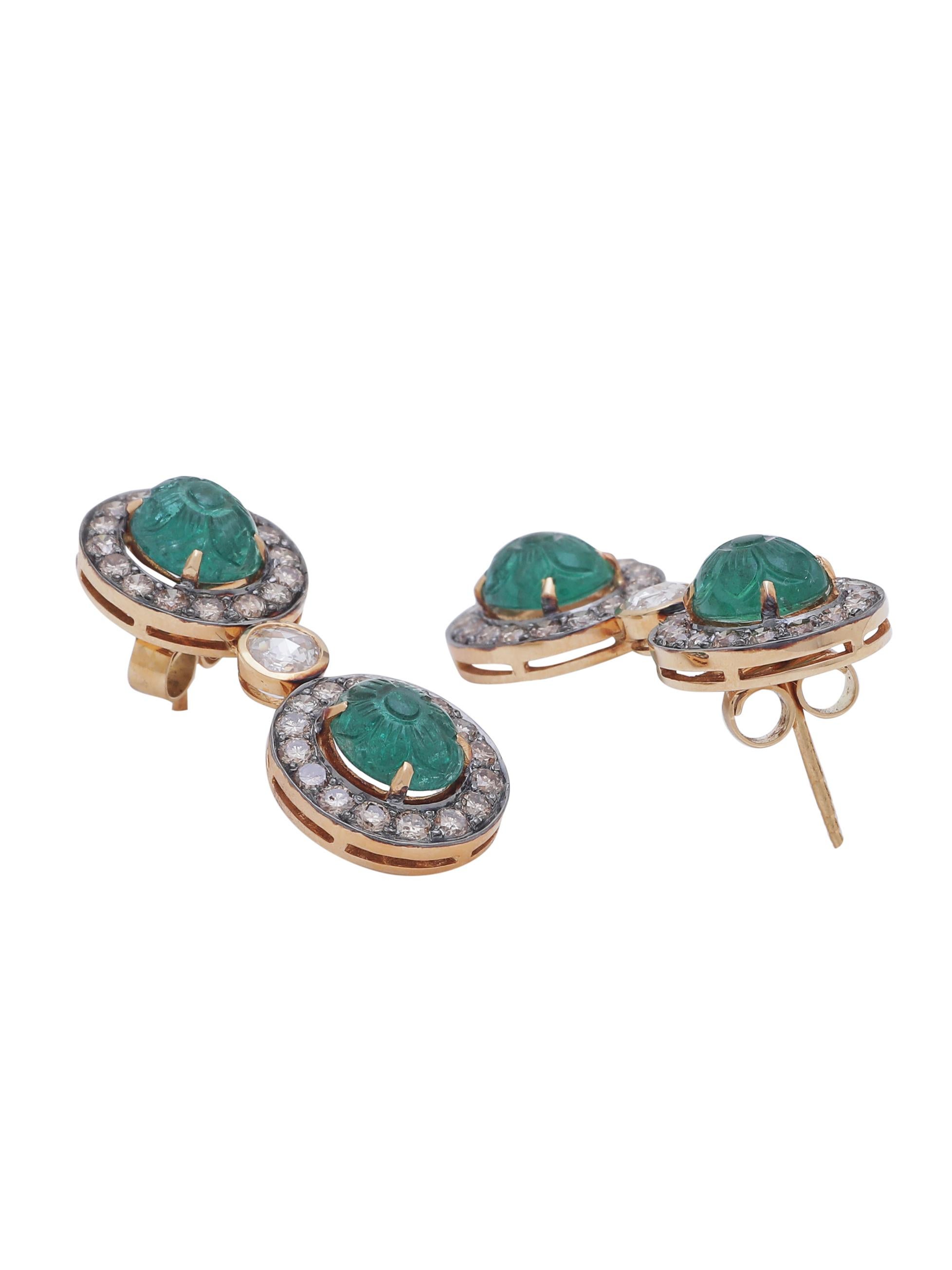A beautiful earring pair with Zambian Natural Hand carved emerald set with diamonds all around and a pair of Round clean rosecut diamonds in the centre.
The carving with floral motif is inspired by the Mughal art of engraving on precious stones and