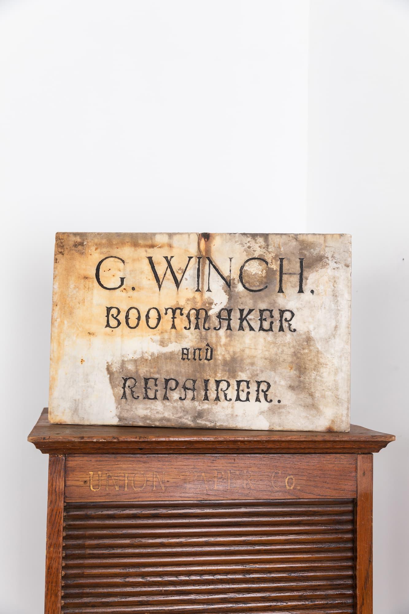 

A superb hand engraved boot makers trade sign. c.1920

Hand carved lettering on alabaster for 'G. WINCH, BOOTMAKER AND REPAIRER'. Fantastic font, form and patina. A small historic fisure to the top but otherwise sound and secure.

