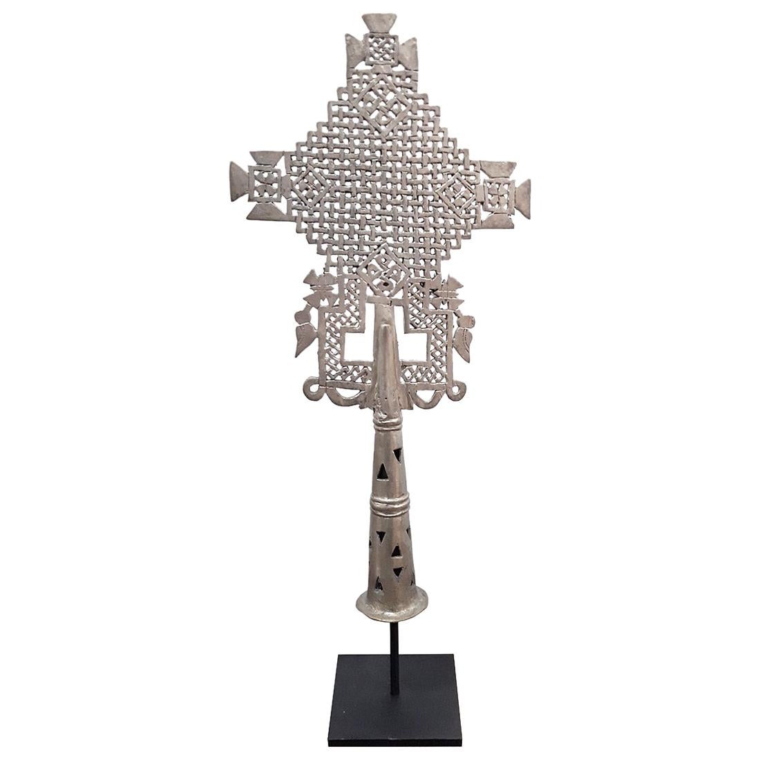 A vintage Coptic cross from Ethiopia, hand carved in silver plated copper, circa 1940. 

These silver, copper or brass crosses are symbols of Coptic / Orthodox Christianity in Ethiopia and Eritrea. Their elaborate design distinguishes them from
