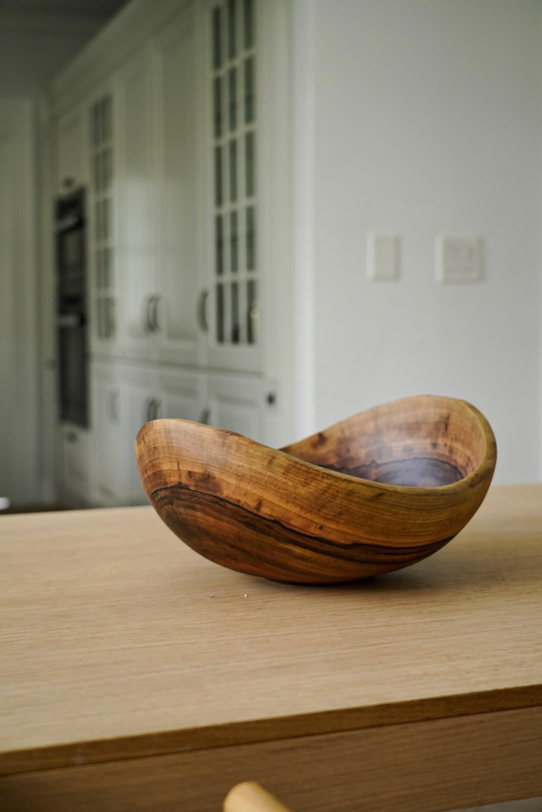 This large wood bowl will become a centerpiece on your table and a perfect vessel for all your fruits or vegetables in the kitchen. Hand-carved from one solid piece of walnut wood, the shape continues the wooden rings and puts the age and the beauty
